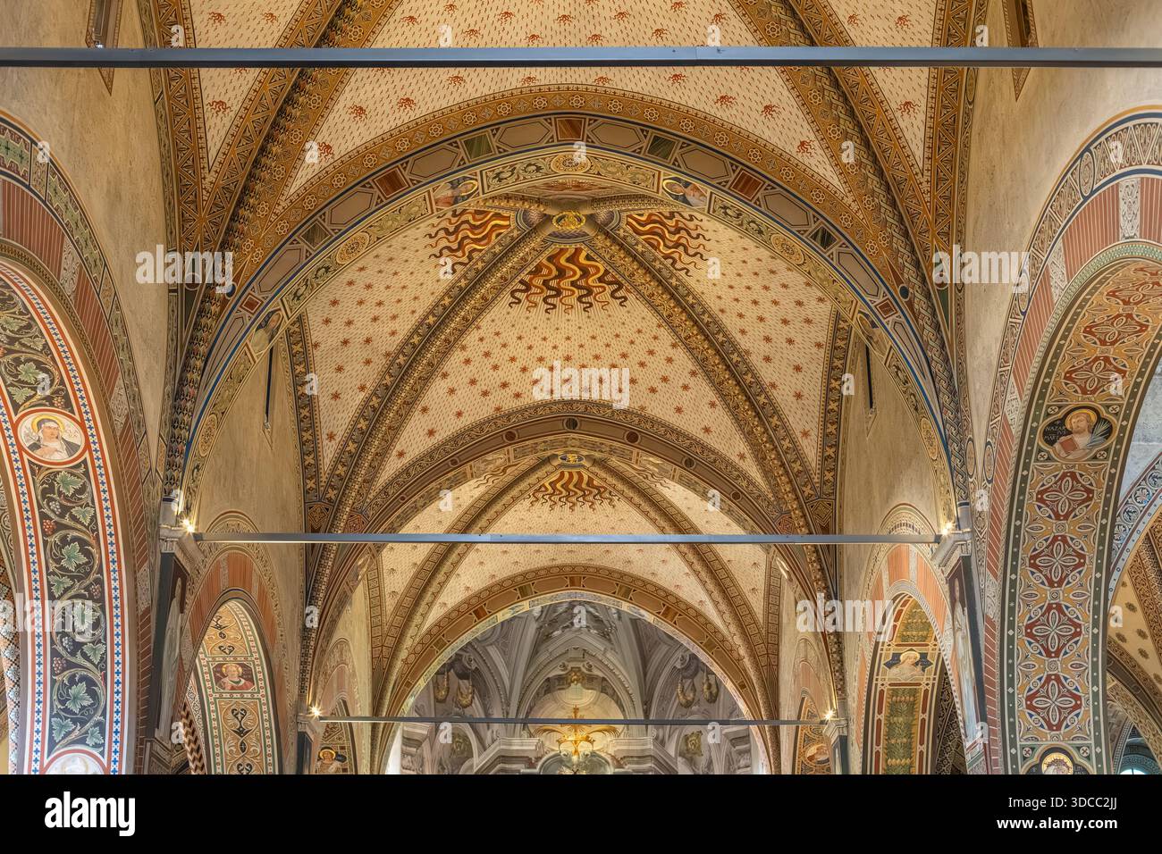 Eine komplizierte gewölbte Decke mit farbenfrohen geometrischen Mustern, Bögen und dekorativen Motiven in einem historischen Kircheninnenraum. Reiche Handwerkskunst erinnert an Sack Stockfoto