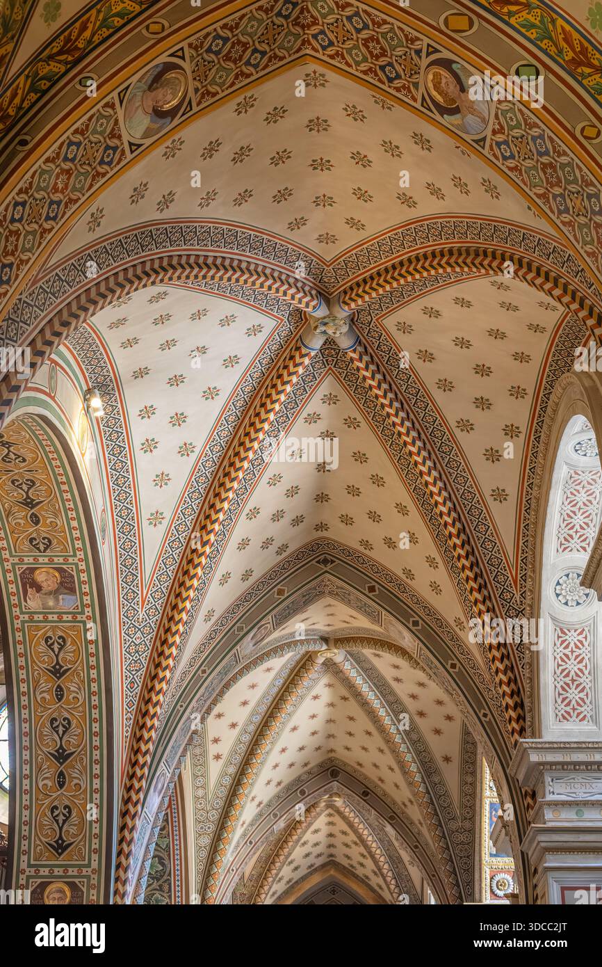 Eine komplizierte gewölbte Decke mit farbenfrohen geometrischen Mustern, Bögen und dekorativen Motiven in einem historischen Kircheninnenraum. Reiche Handwerkskunst erinnert an Sack Stockfoto