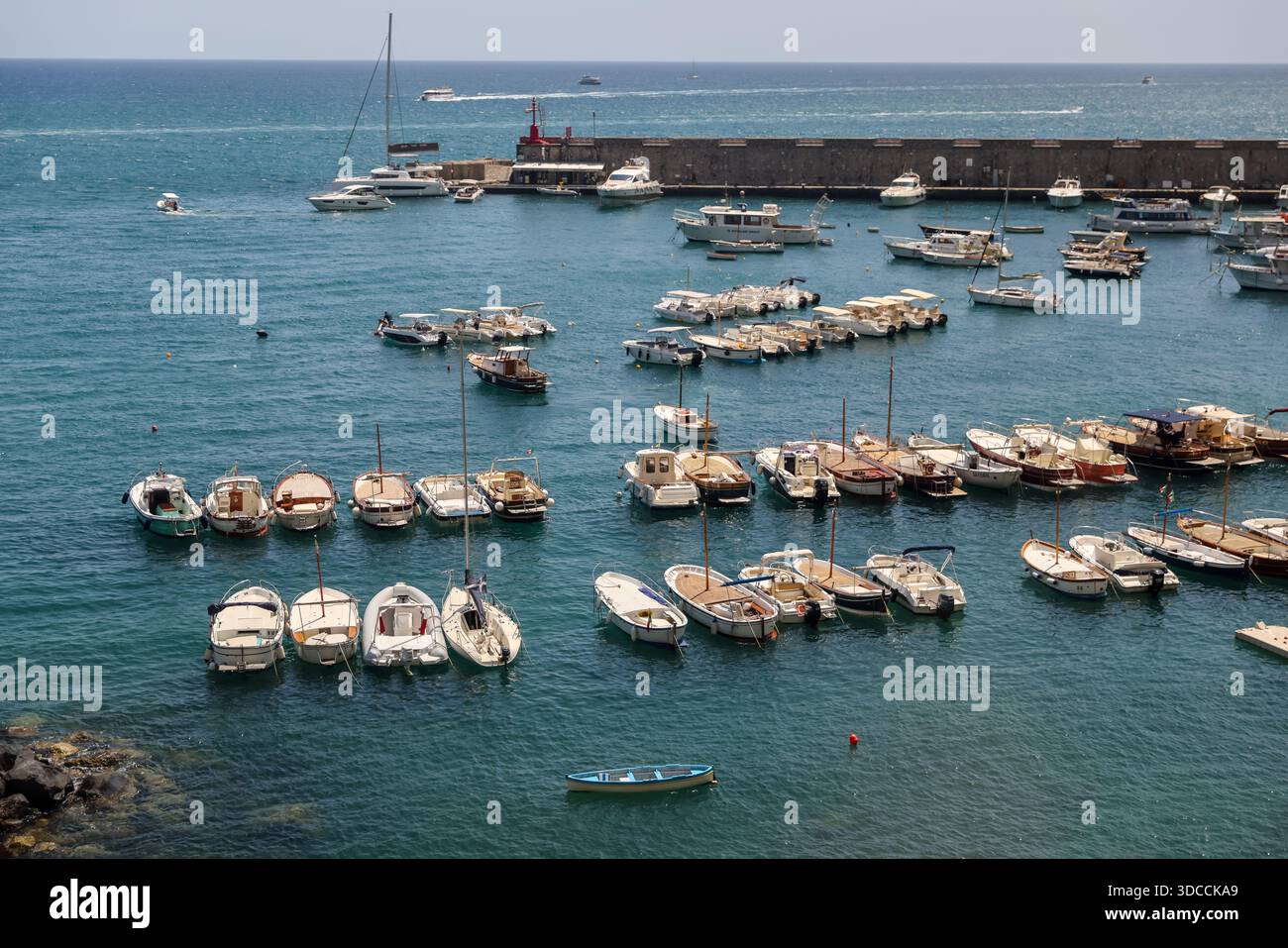 Kleine Boote, die in einem geschützten Yachthafen entlang der Amalfiküste unter klarem blauen Himmel vor Anker gehen. Stockfoto