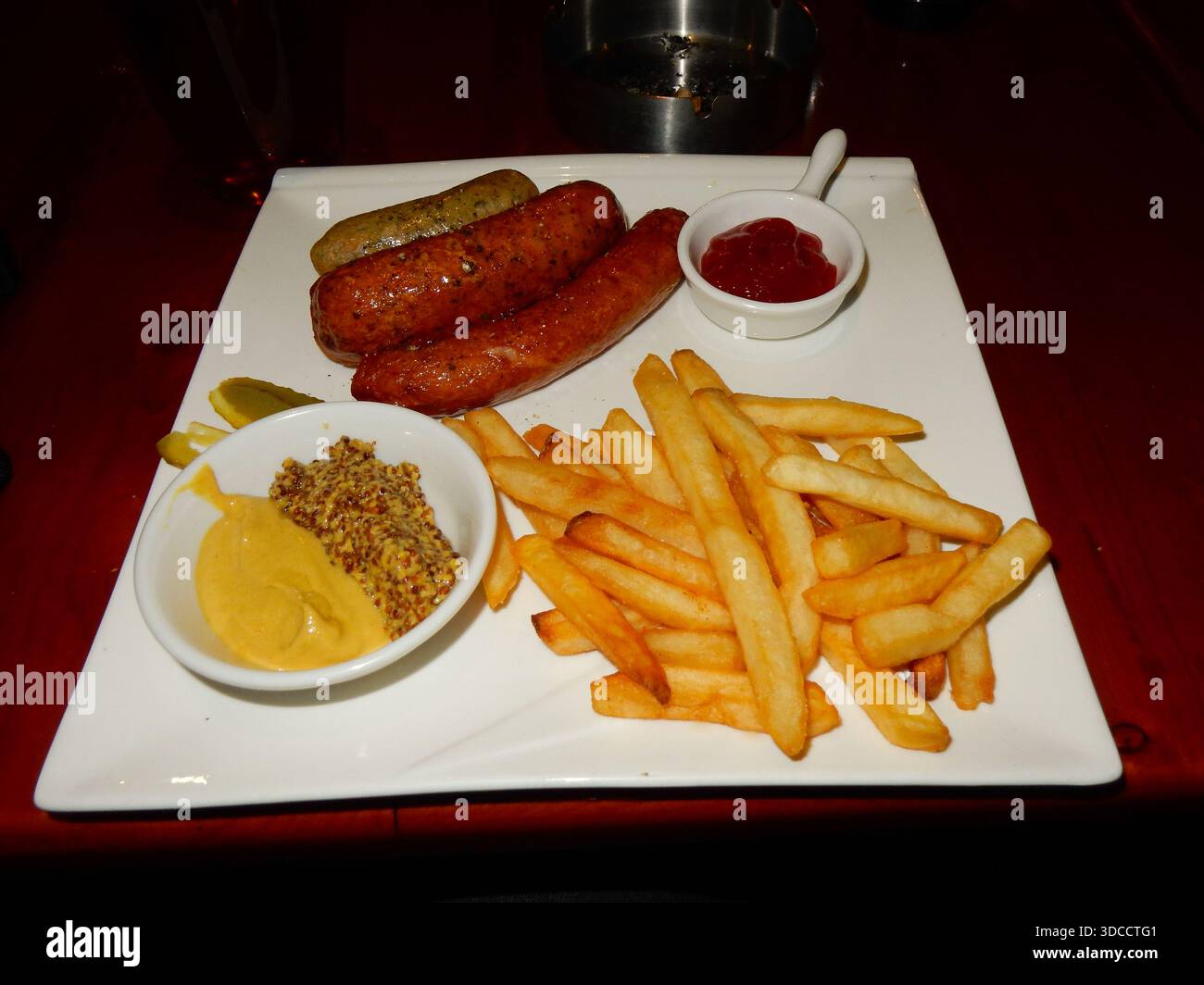 Ein Teller mit Würstchen, Senf und Pommes frites in einer Bar in Luoyang Stockfoto