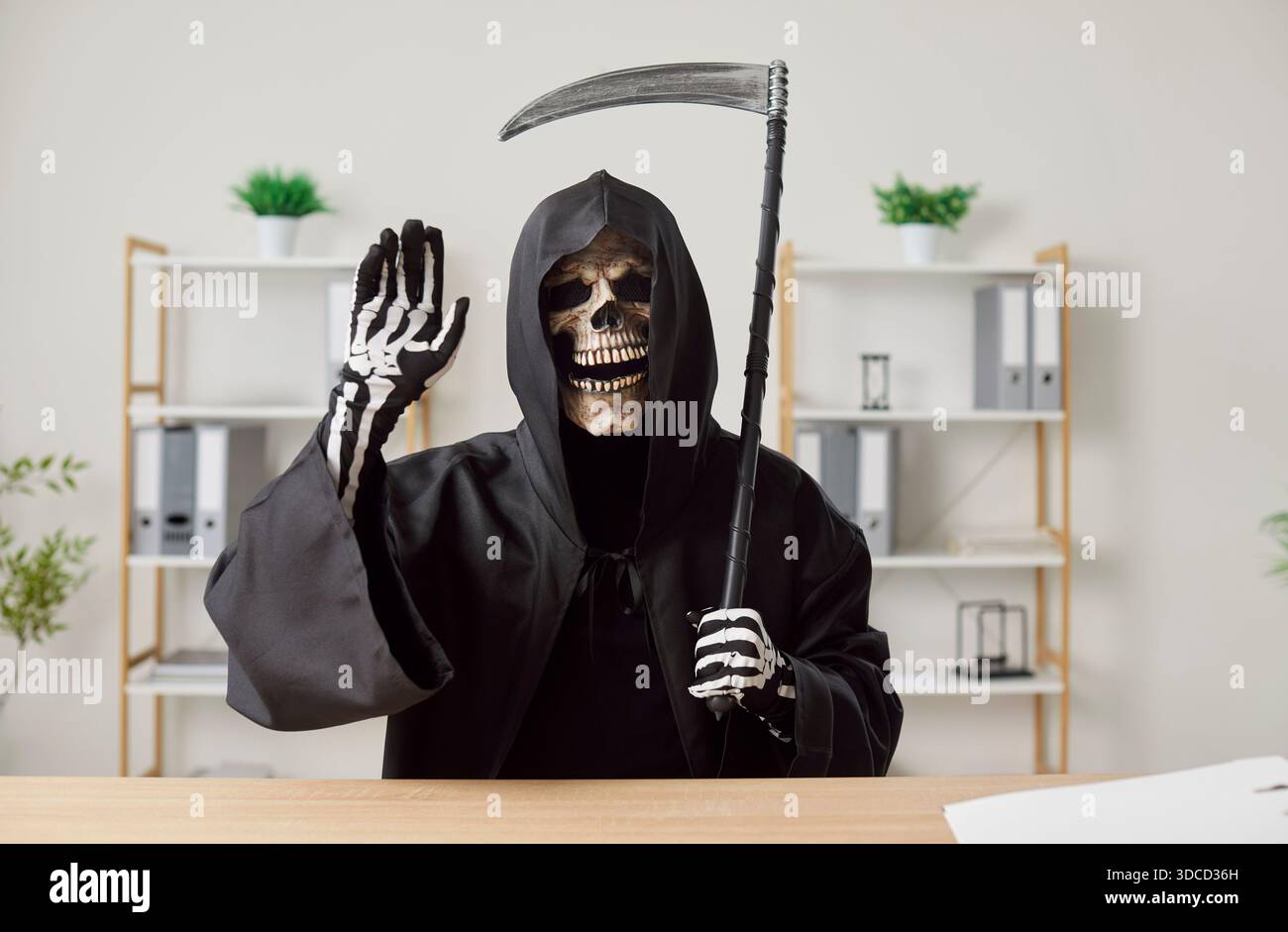 Grim Reaper Winkt Hand Am Schreibtisch Im Büro Stockfoto