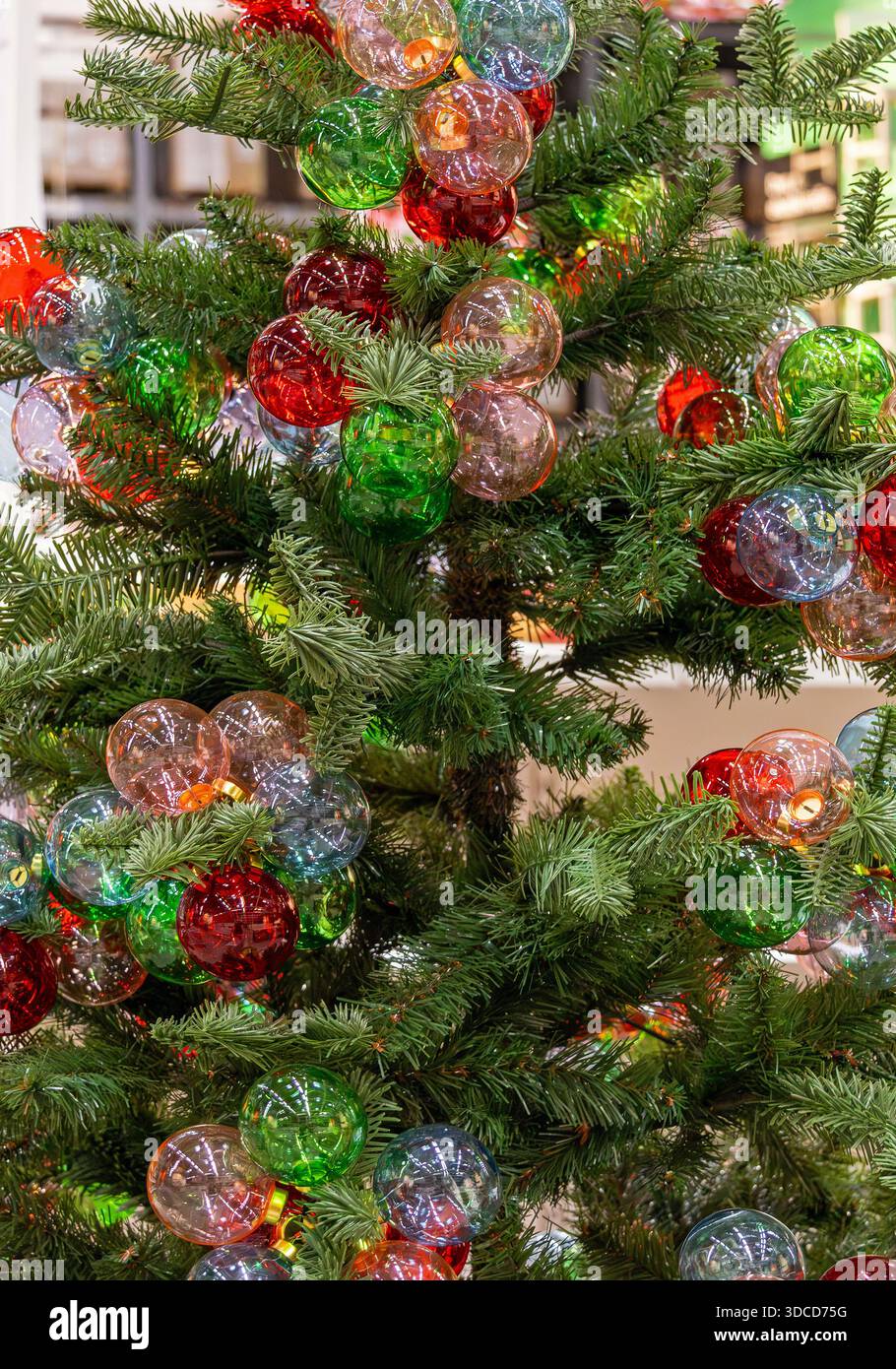 Dekorierter naturgrüner Weihnachtsbaum mit farbenfrohen festlichen Ornamenten Stockfoto