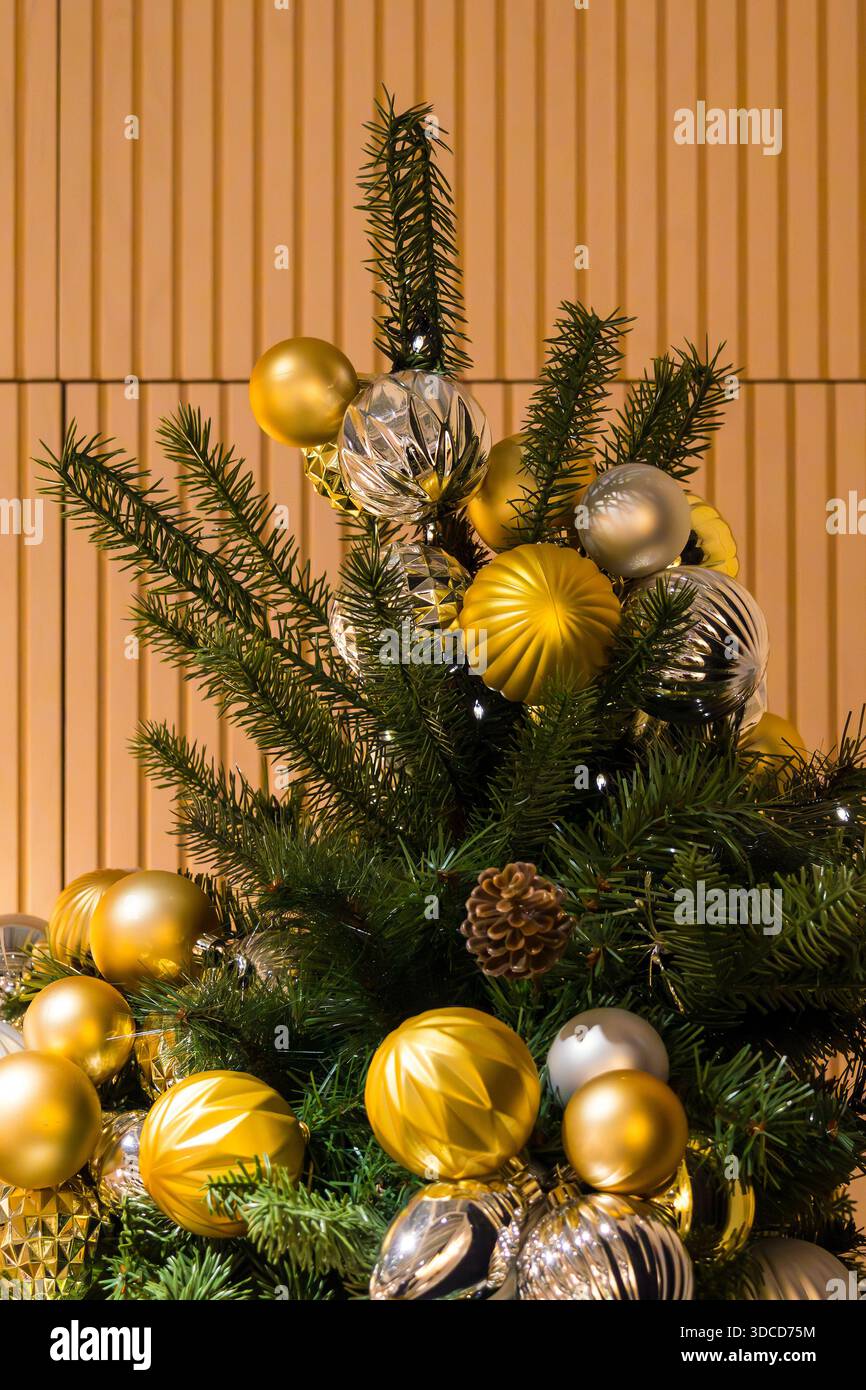 Weihnachtsbaum mit goldenen Festschmuck im Inneren des Zimmers Stockfoto