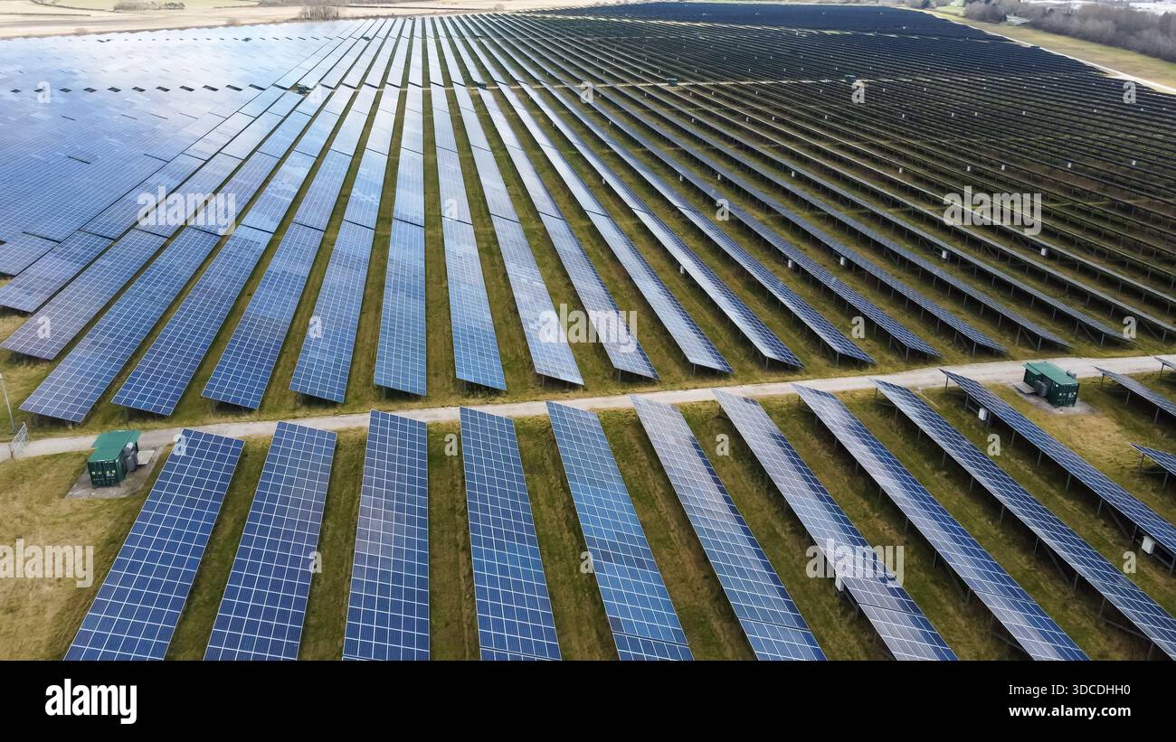 Luftaufnahme von Reihen von Solarpaneelen in einem großen Solarpark, der erneuerbaren Strom erzeugt Stockfoto