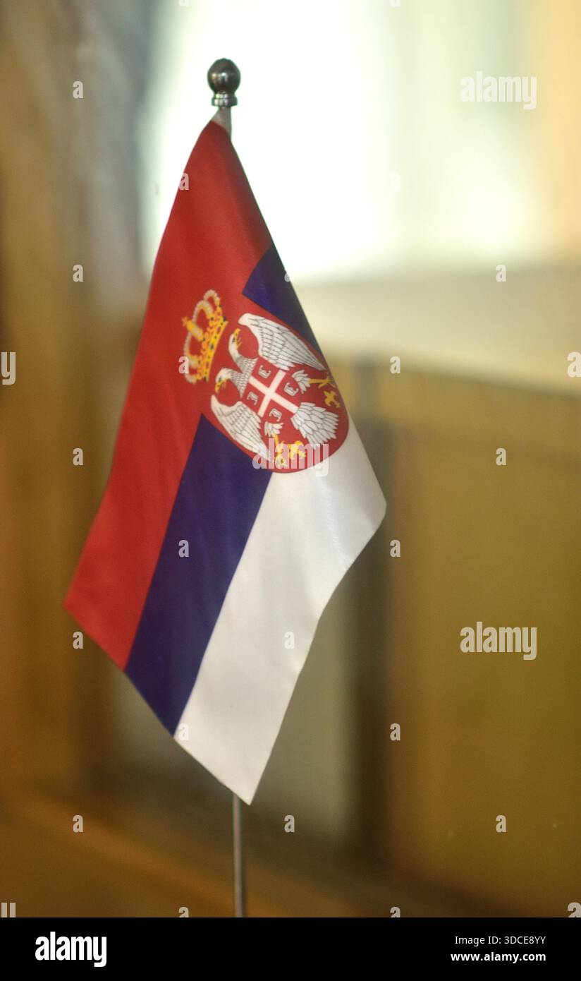 Eine kleine serbische Flagge auf einem Stand drinnen. Stockfoto