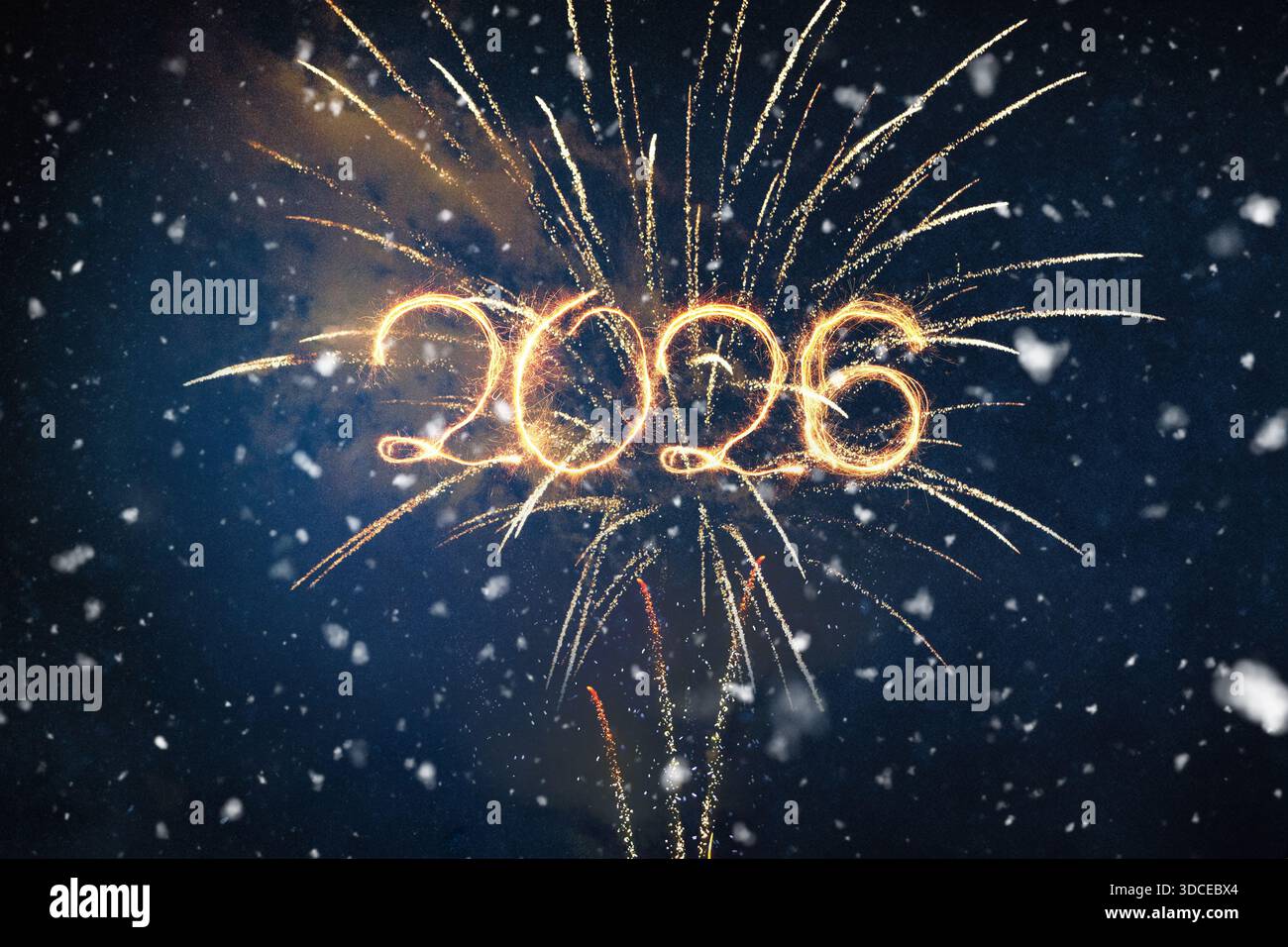 Heller Text von 2026 mit goldenen Funken oder Lichtspuren, überlagert über einem atemberaubenden Feuerwerk in einem dunklen, verschneiten winterlichen Nachthimmel. New Yea Stockfoto