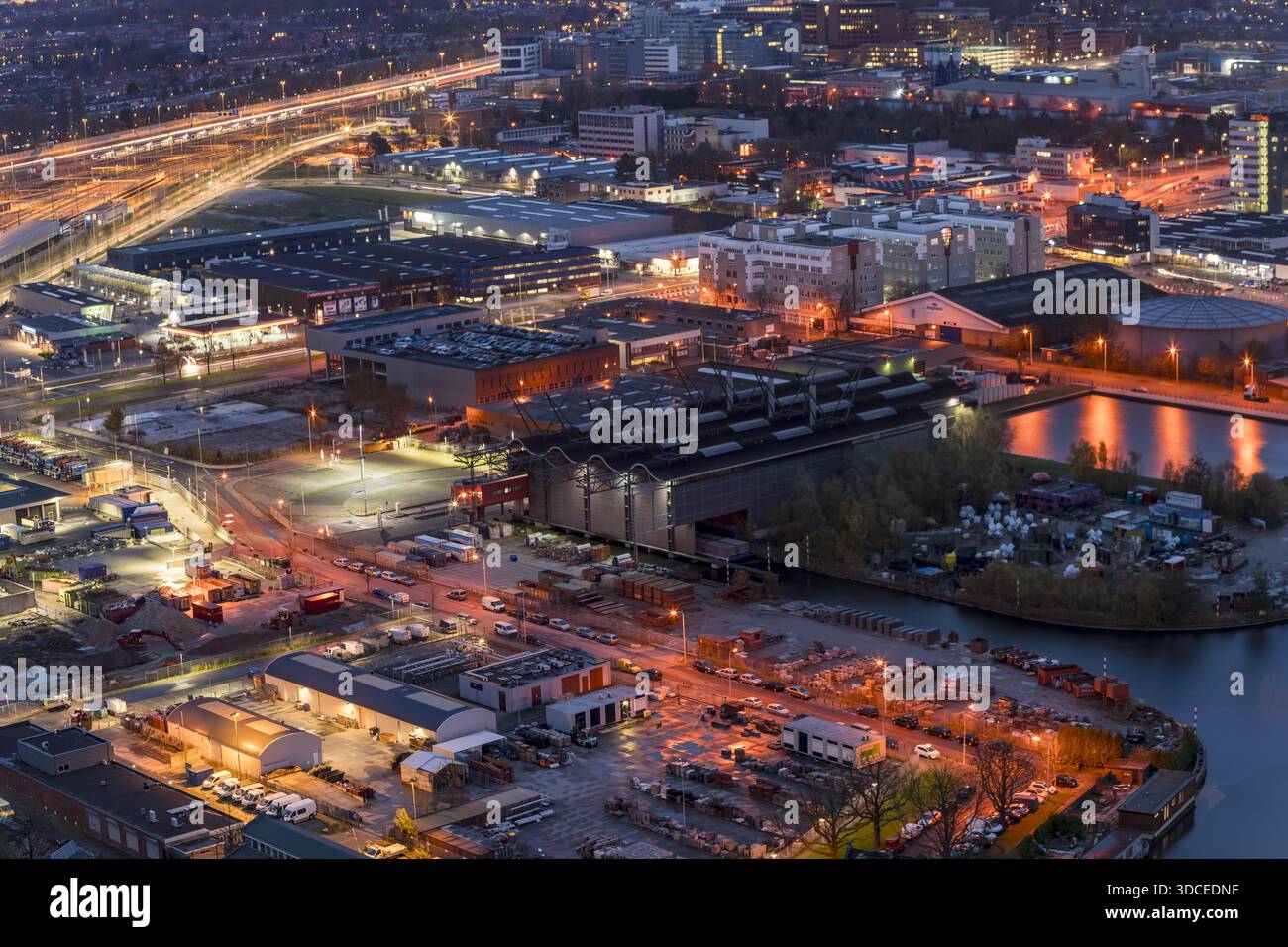 The Haag, Niederlande - 20. November 2016: Blick auf ein pulsierendes Stadtbild im warmen Licht der Dämmerung, mit Industriegebäuden, die sich auf die Th spiegeln Stockfoto