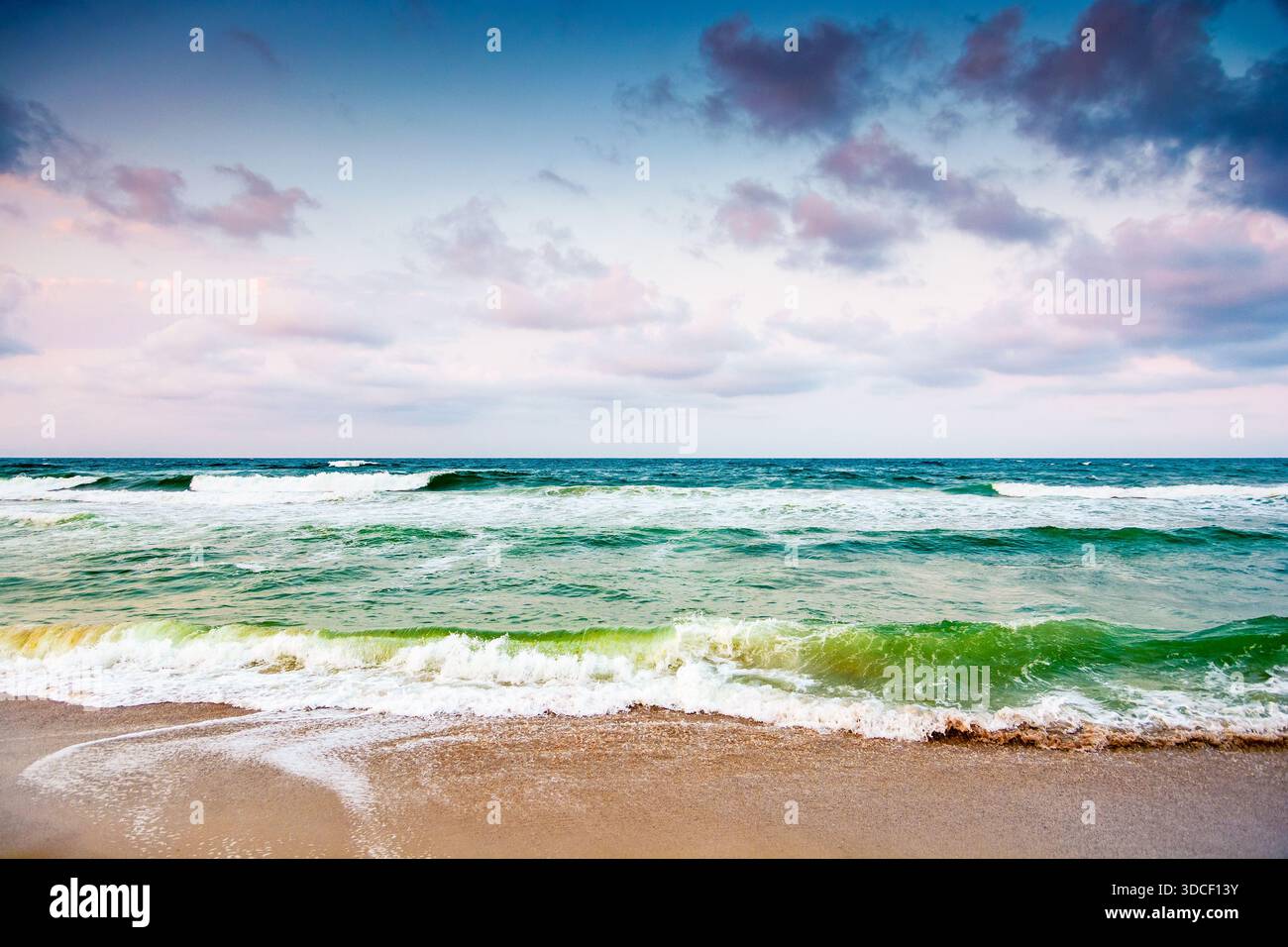 Schwarze Meereswellen stürzen auf den Sandstrand bulgariens. Sommerurlaub an einem windigen Tag unter dunklem bewölktem Himmel. Blick auf die dramatische Meereslandschaft. Hintergrund Stockfoto