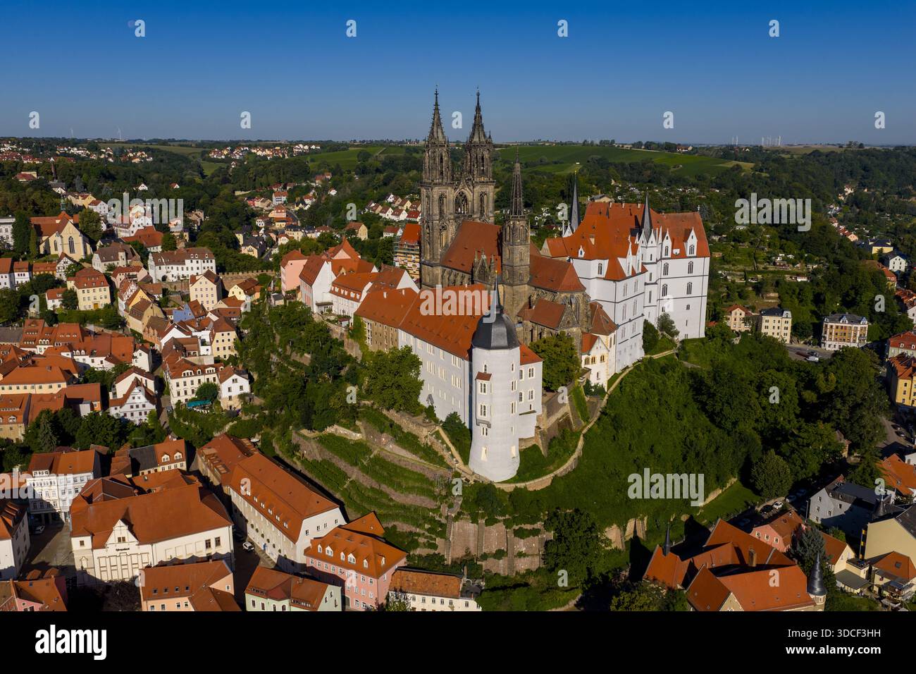 Aus der Vogelperspektive auf ein majestätisches Schloss mit roten Dächern, die sich von den weißen Wänden abheben, auf einem Hügel mit Blick auf die Stadt Meißen, Sachsen, Deutsch Stockfoto