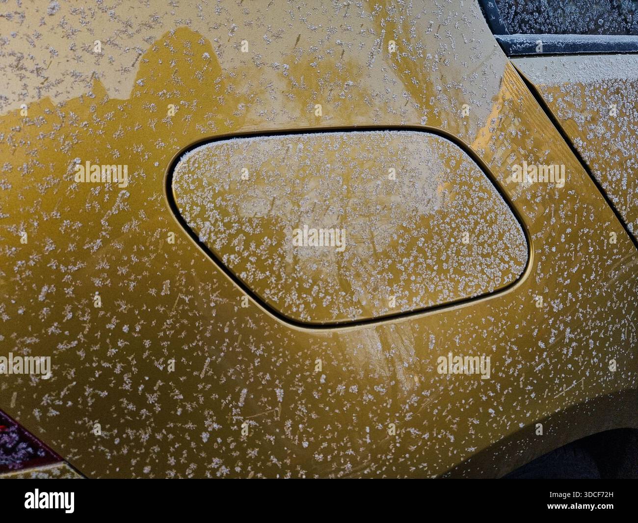 Winterfahren – Frost- und Eiskristalle auf dem Tankdeckel. Tankdeckel für Autos in Metallic-Gold am hinteren rechten Seitenblech. Rautenförmiger Kraftstoffgasdeckel. Stockfoto