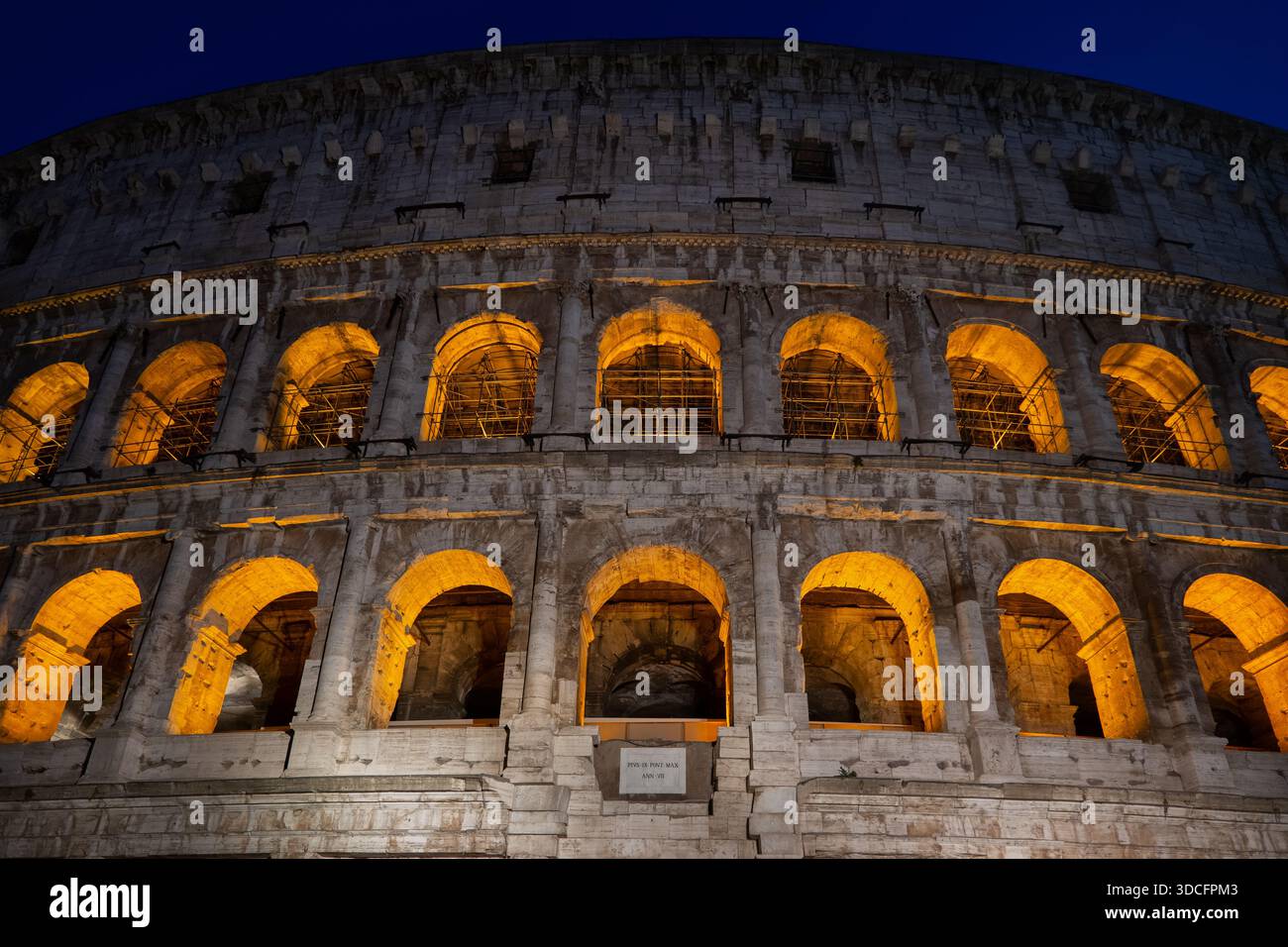 Bögen des Kolosseums, altes Flavianisches Amphitheater bei Nacht in Rom, Italien. Stockfoto