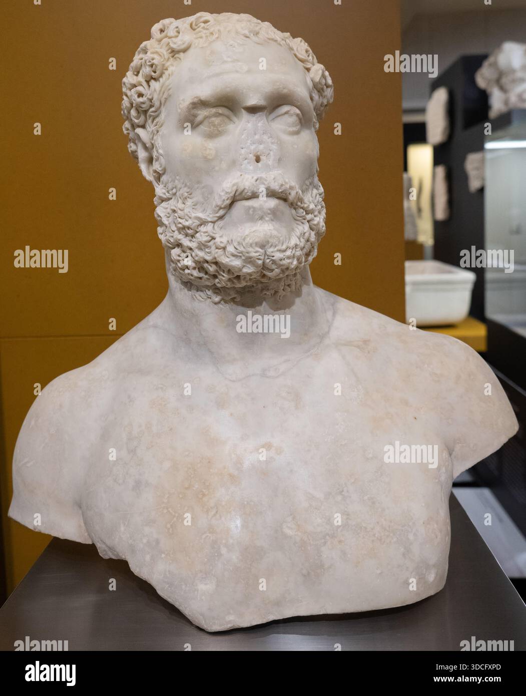 Cordoba, Spanien - 21. Mai 23: Marmorbüste eines bärtigen Mannes mit lockigen Haaren, die klassische Skulpturendetails aus dem Archäologischen Museum von Córdoba zeigt Stockfoto