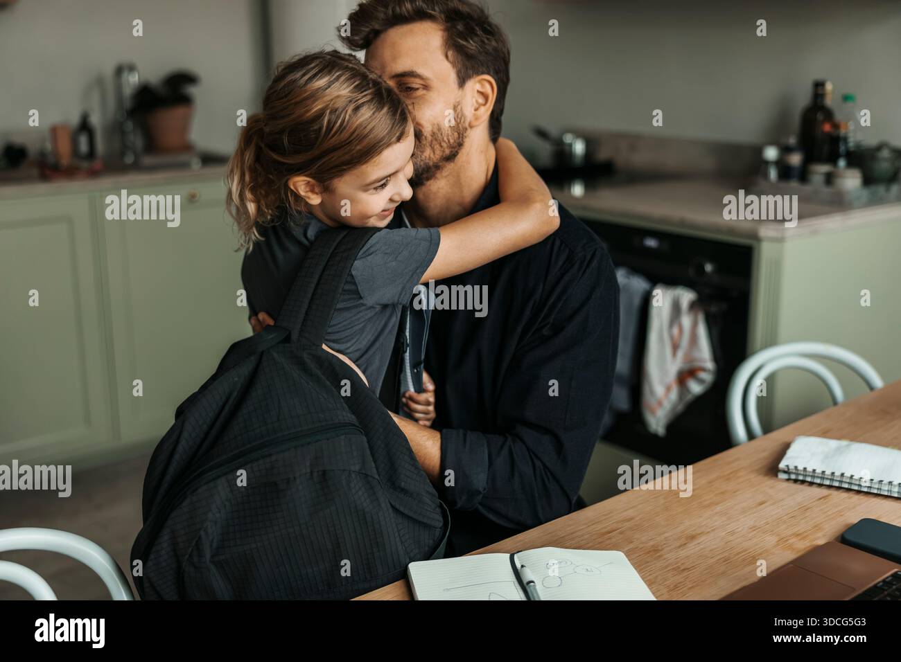 Vater küsst Tochter, der von der Schule zu Hause zurückkommt Stockfoto