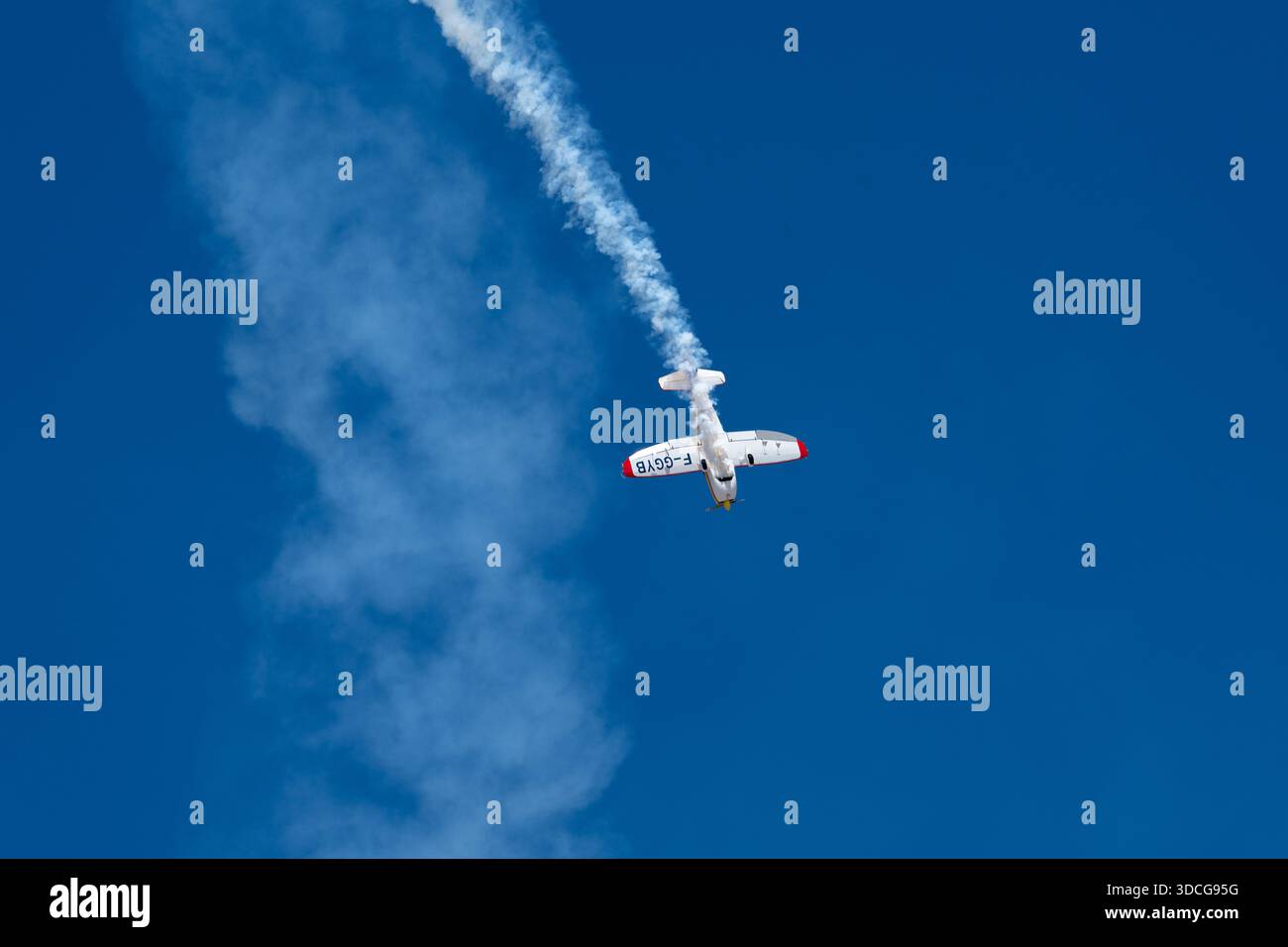 Moron, Spanien - 12. Mai 23: Ein Stunt Mudry CAP-10B Flugzeug, das eine Schleife in einem klaren blauen Himmel durchführt und eine Rauchspur hinterlässt Stockfoto