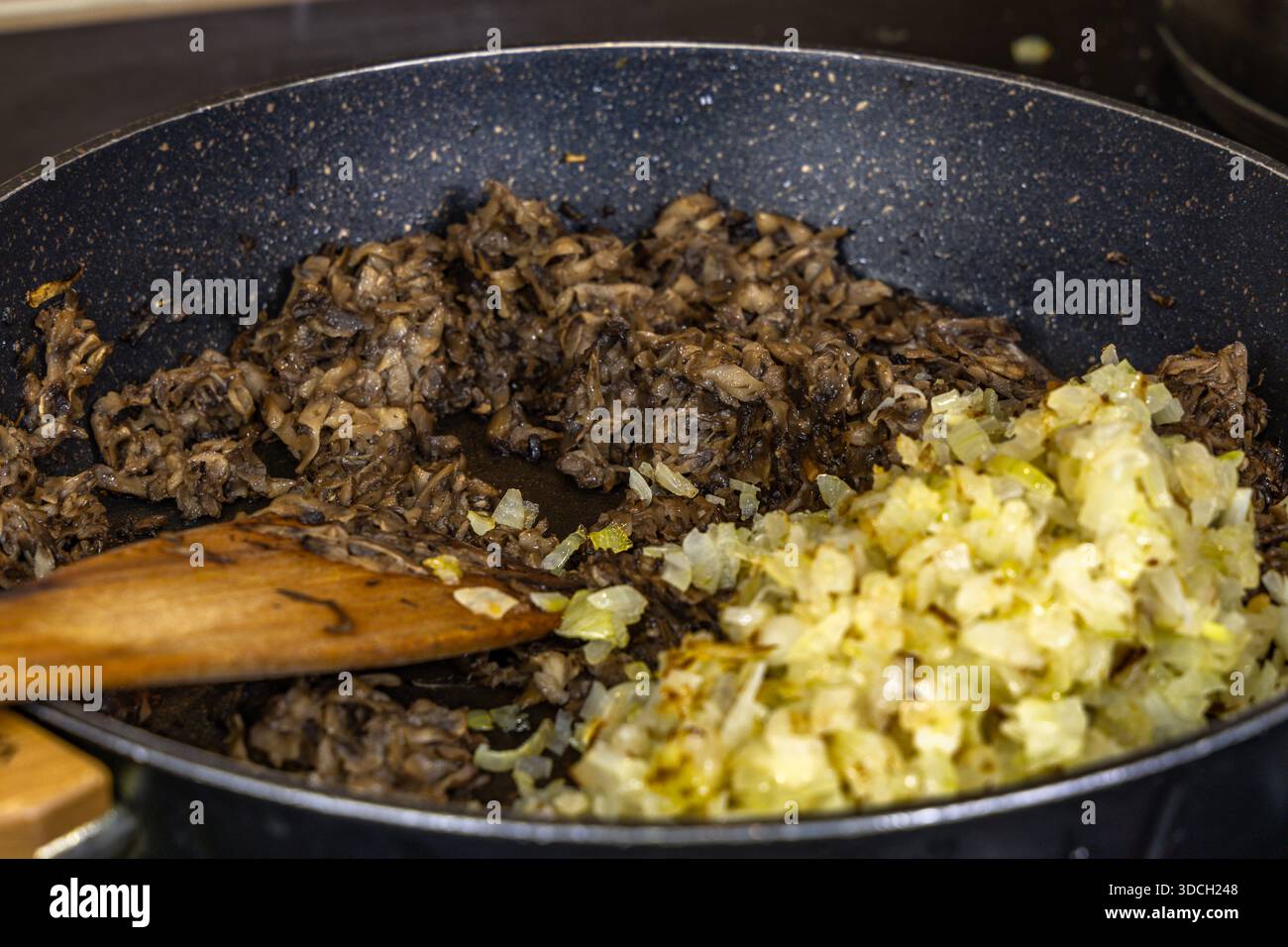 Zwiebeln und Pilze in einer Pfanne braten, ein realistisches Foto aus der Küche, Gerichte für die Feiertage vorbereiten Stockfoto