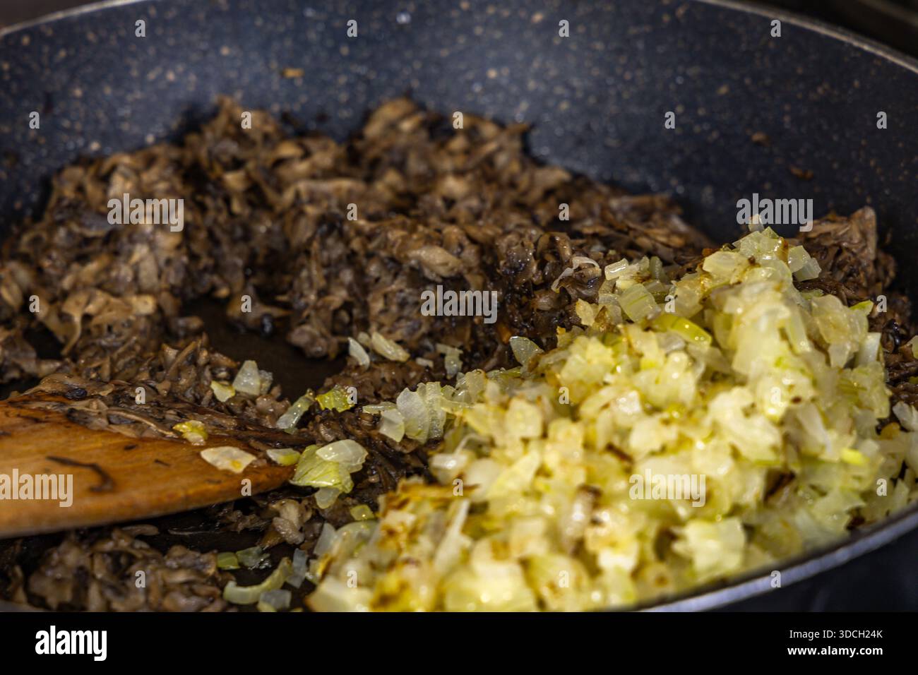 Zwiebeln und Pilze in einer Pfanne braten, ein realistisches Foto aus der Küche, Gerichte für die Feiertage vorbereiten Stockfoto