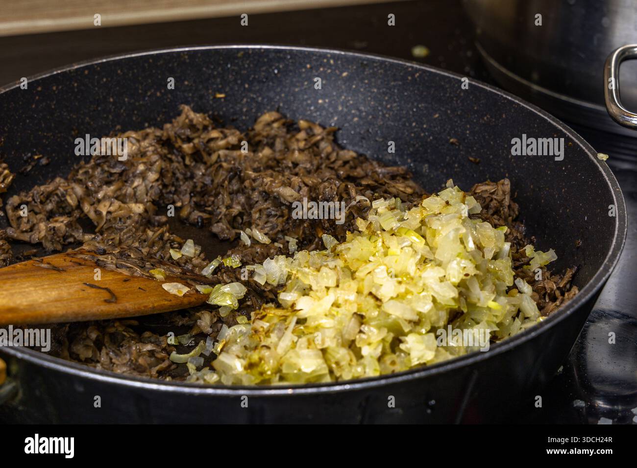 Zwiebeln und Pilze in einer Pfanne braten, ein realistisches Foto aus der Küche, Gerichte für die Feiertage vorbereiten Stockfoto