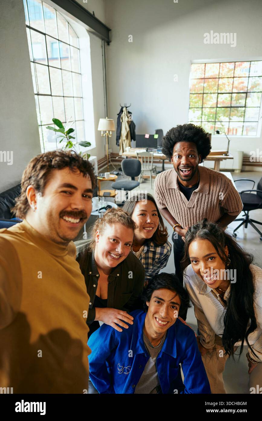 Porträt eines glücklichen Geschäftsmannes, der Selfie mit Kollegen im Startup-Büro macht Stockfoto