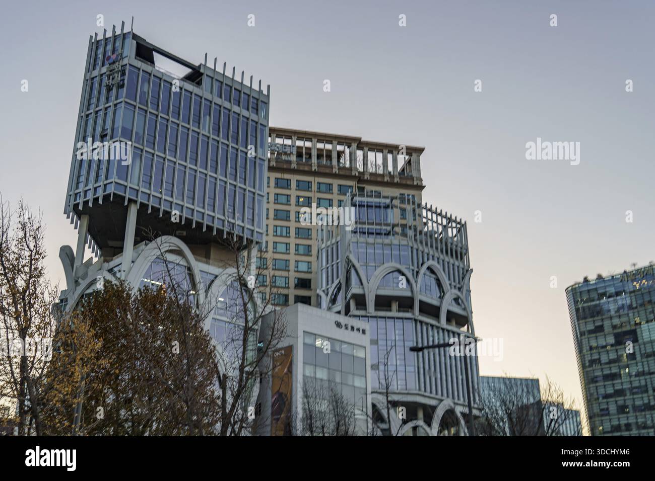 Moderne Gebäude mit einzigartiger Architektur und Bäumen im Vordergrund vor dem Himmel, Seoul, Südkorea Stockfoto