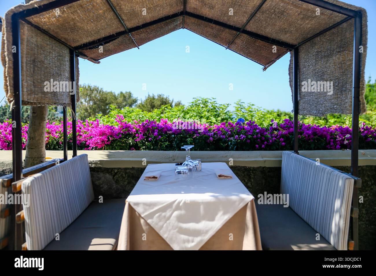 Intime Essnische im Freien mit einem Tisch mit Blick auf die blühenden Gärten auf der Insel Capri, Italien. Stockfoto
