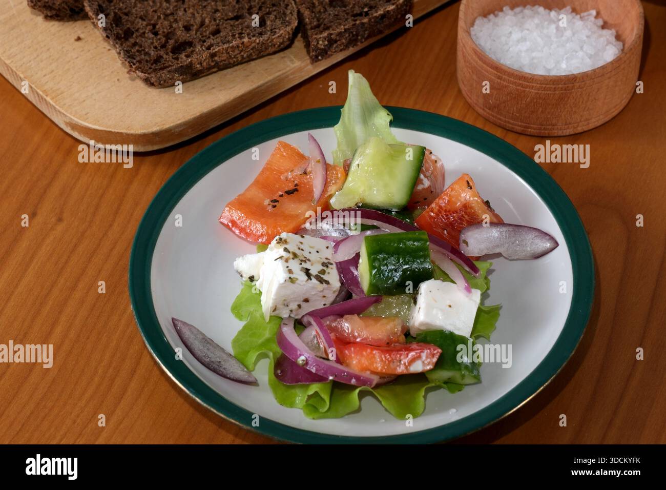 Farbenfroher Salat mit Gemüse und Käse, serviert auf einem rustikalen Tisch. Stockfoto