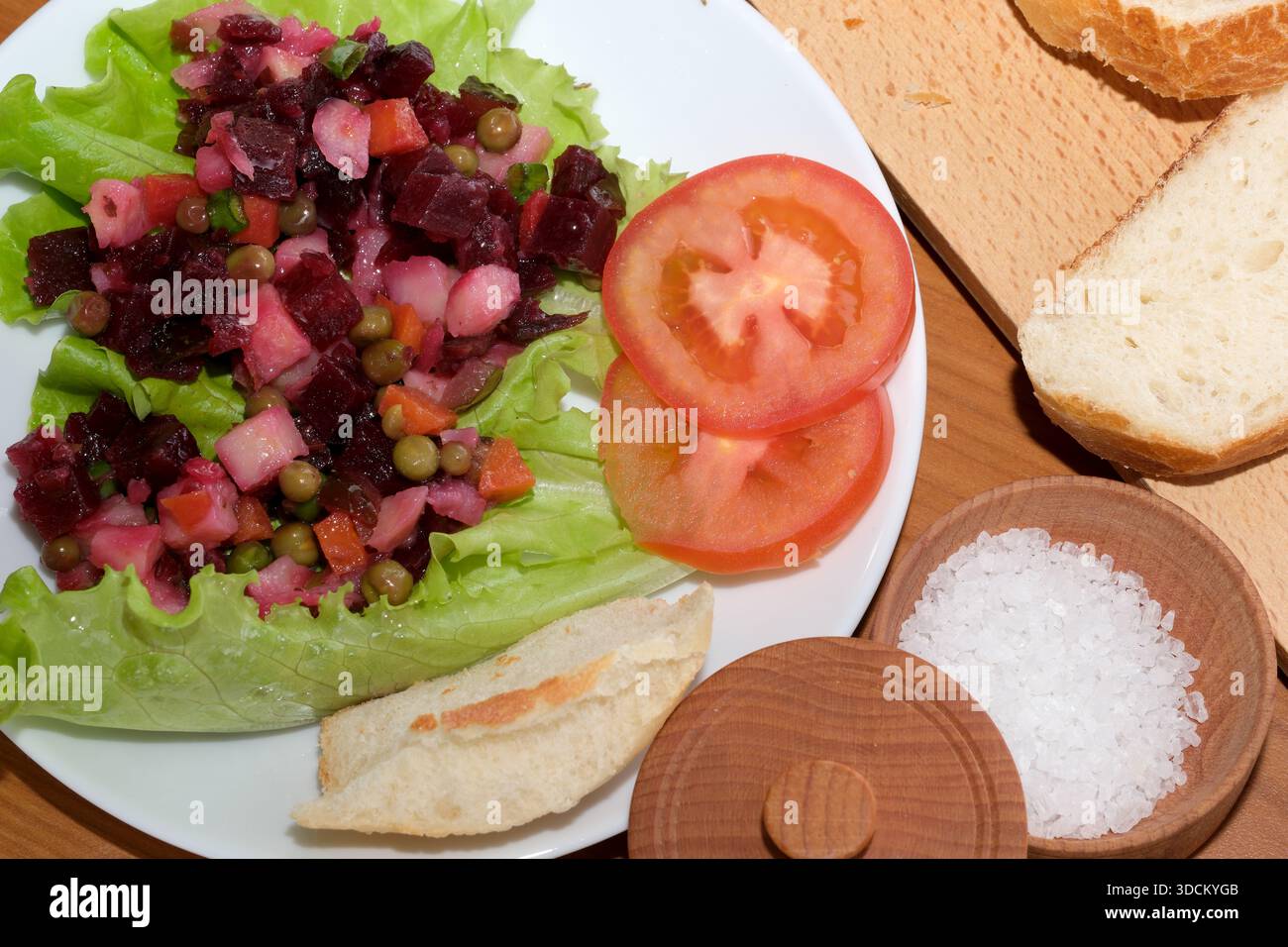 Lebendiger Salat mit Rüben und Gemüse, serviert mit frischen Brotscheiben. Stockfoto