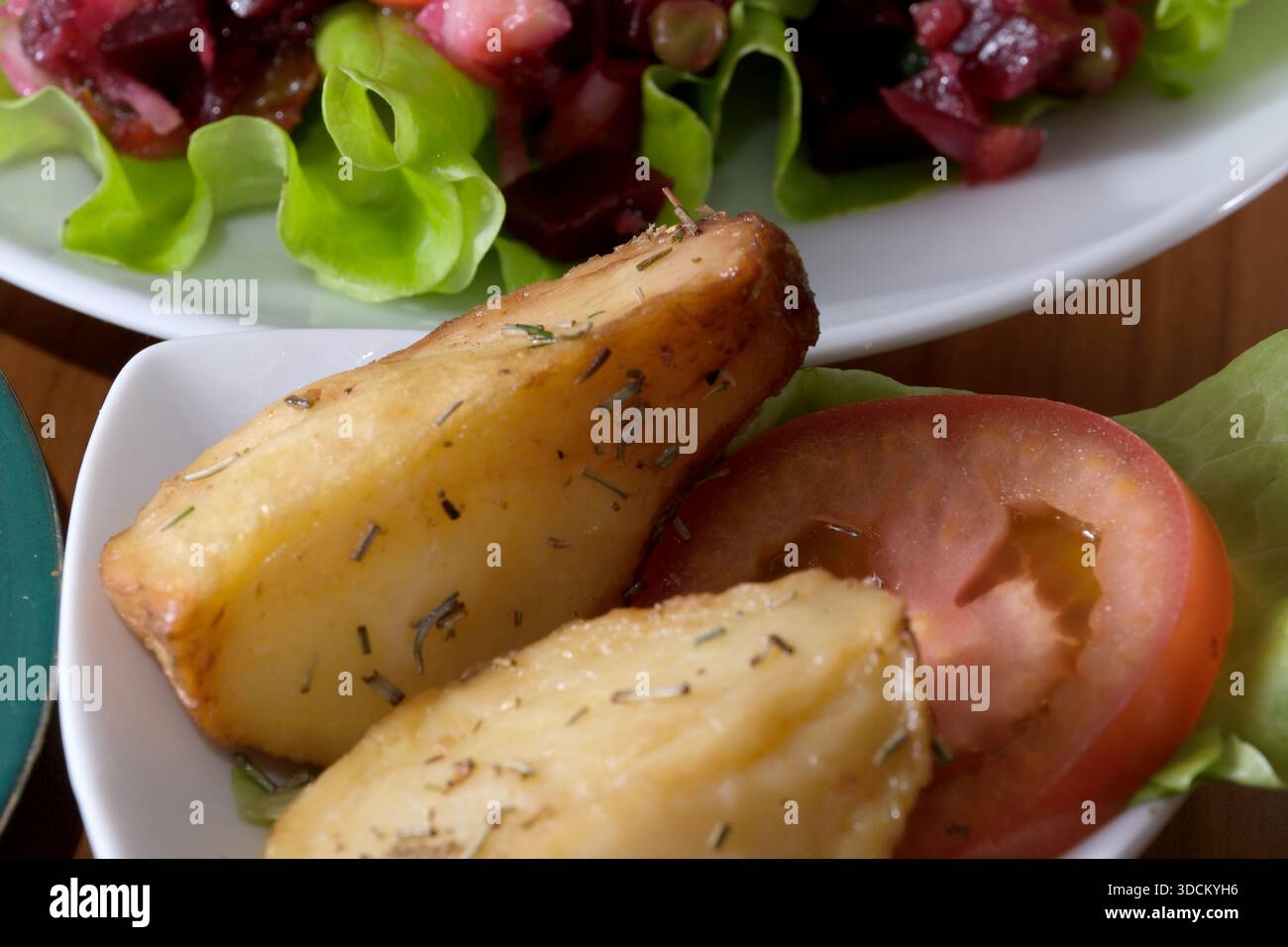Zartes, geröstetes Wurzelgemüse steht neben lebendigem Salat und knusprigem Gemüse. Stockfoto