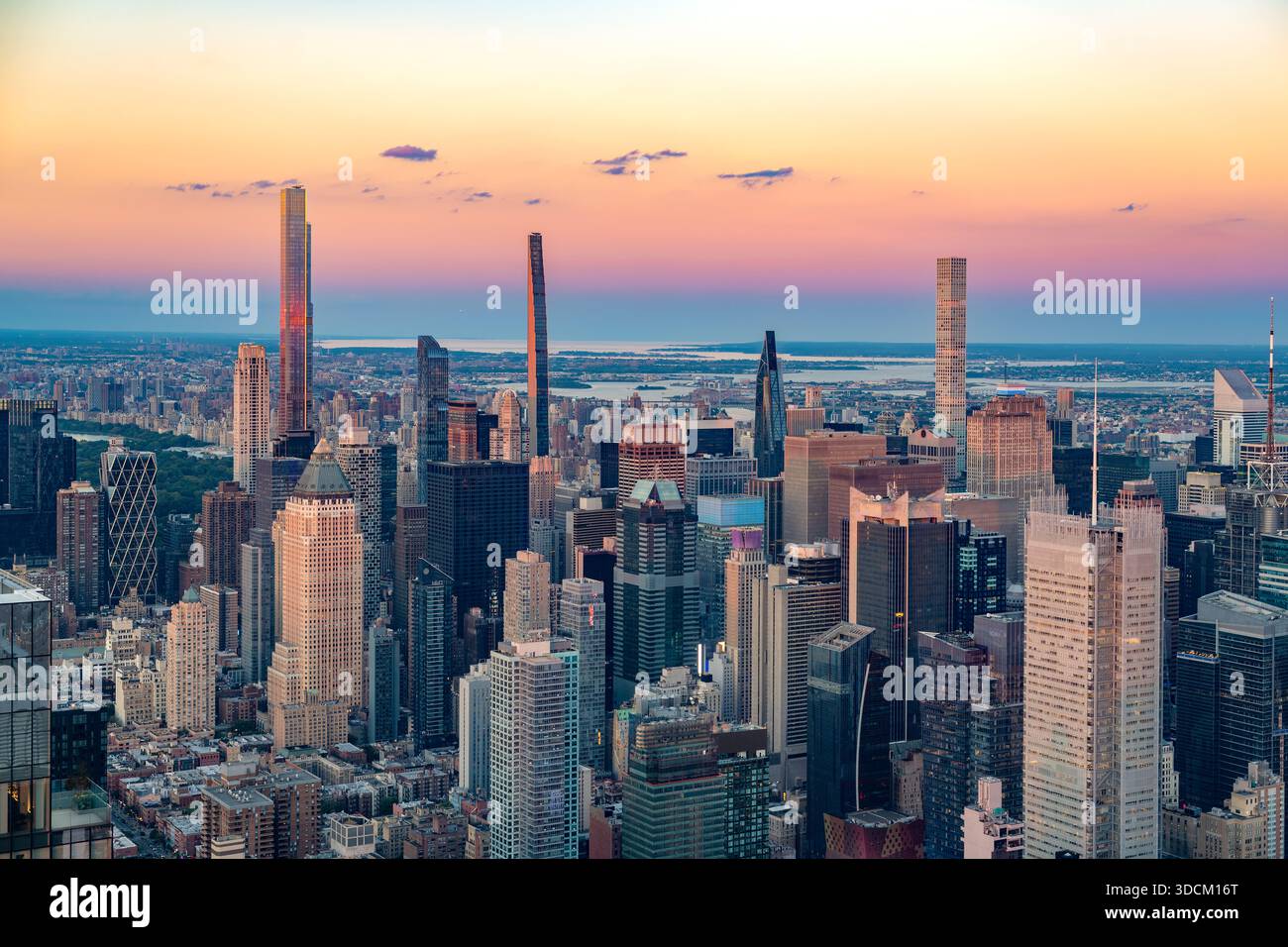 Die legendären Wolkenkratzer der Billionaires Row erheben sich bei einem pulsierenden Sonnenuntergang über der dichten Skyline von Midtown Manhattan. Stockfoto