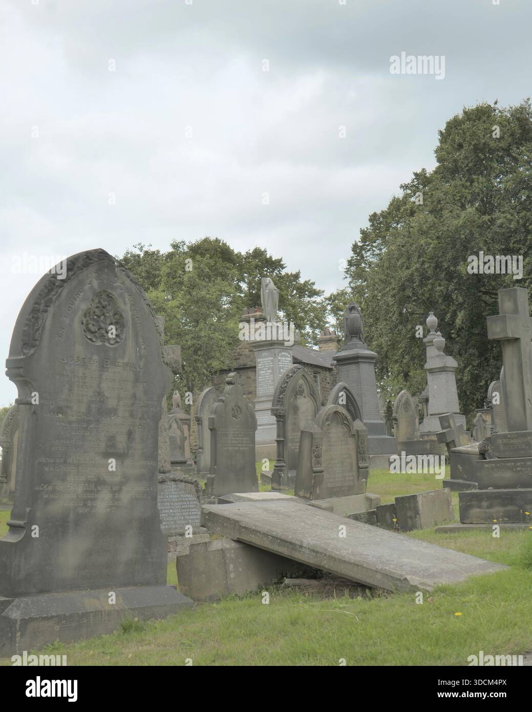 Vertikale Ansicht der Grabsteine auf einem Friedhof mit Gedenkstätten und Grabsteinen in einem ruhigen Friedhof mit gedämpften Farben. Stockfoto