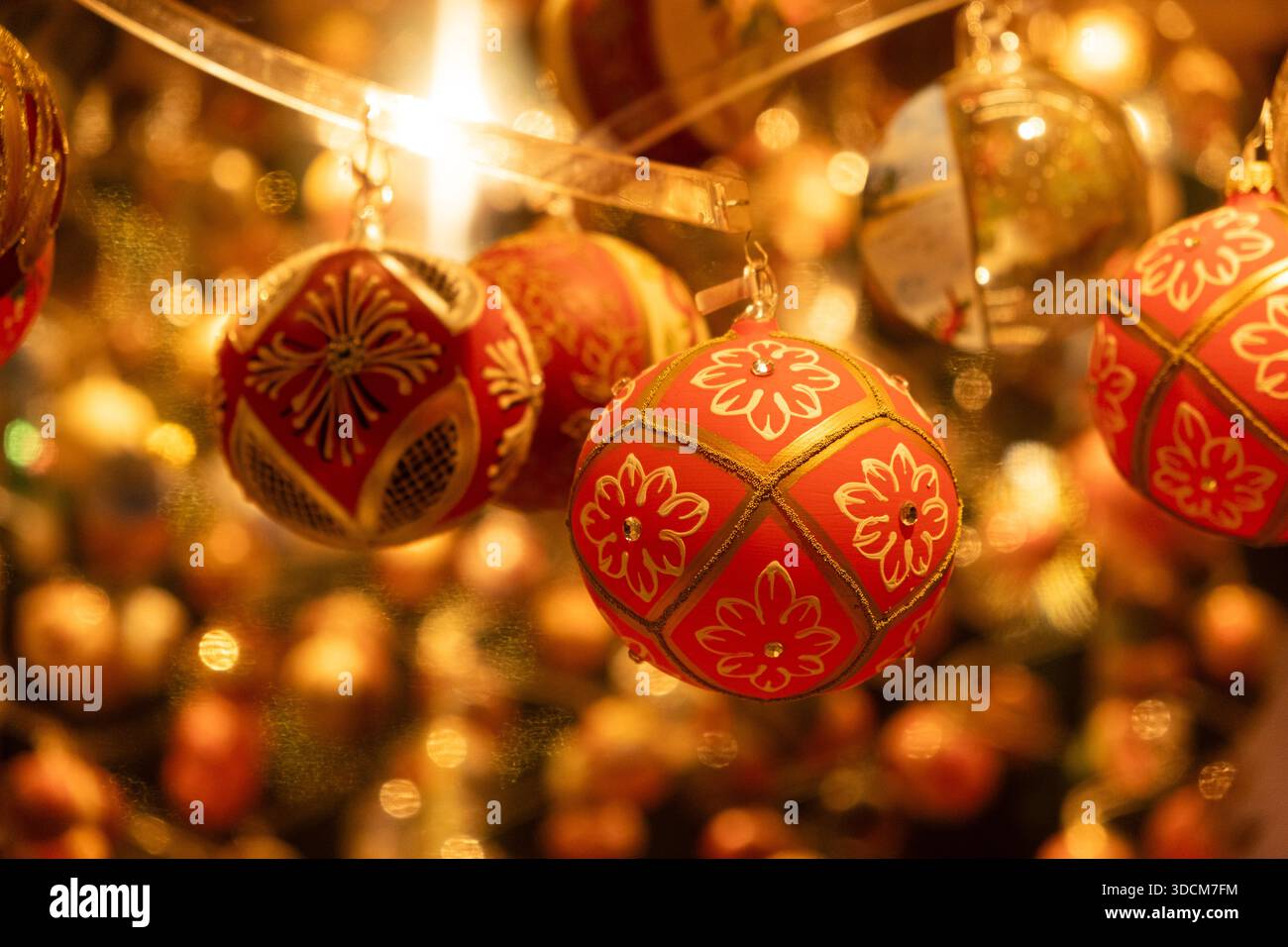 Festlicher Feiertagshintergrund mit leuchtend roten und goldenen Glaskugeln. Stockfoto