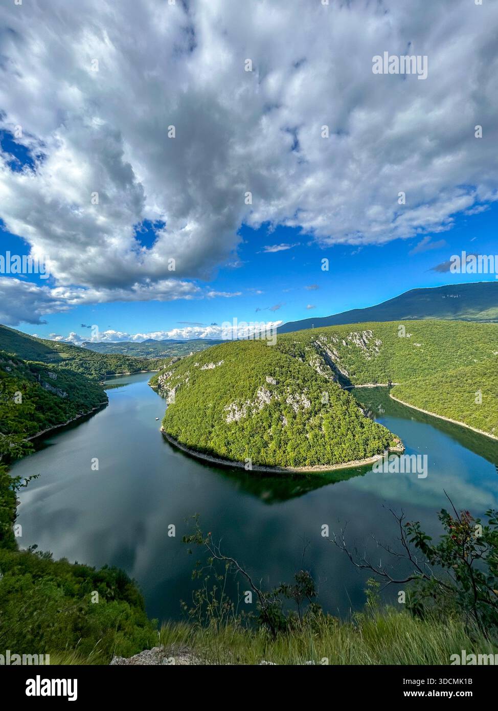 Ein atemberaubender Blick auf den Fluss Vrbas, umgeben von üppigen grünen Hügeln und einem lebendigen Himmel, der die natürliche Schönheit von Bosnien und Herzegowina - Smartphone-aufgenommenes Stockfoto