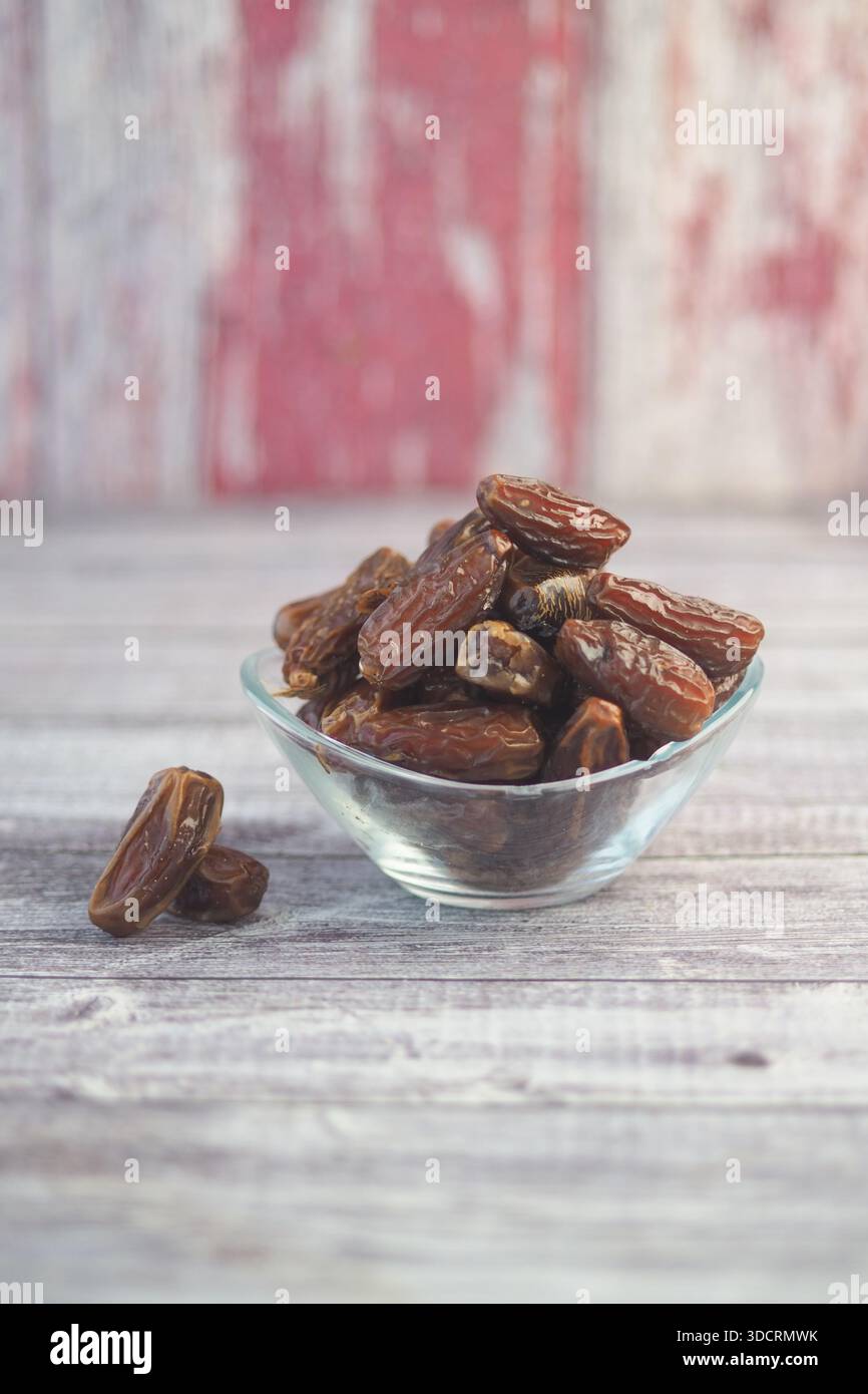 Getrocknete Datteln in einer Glasschale auf einem Holztisch Stockfoto