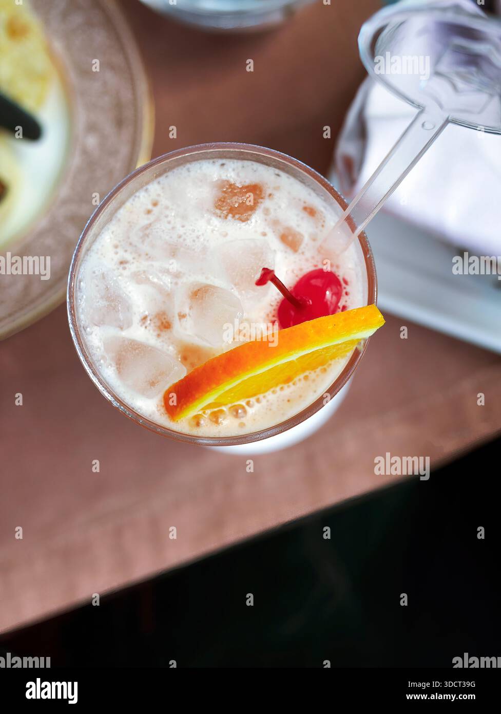 Ein lebendiger, erfrischender Punsch aus roten Früchten oder Cocktail, serviert in einem hohen Glas. Ähnelt einem Mai Tai, Tequila Sunrise oder Erdbeermocktail, gefüllt mit Crys Stockfoto