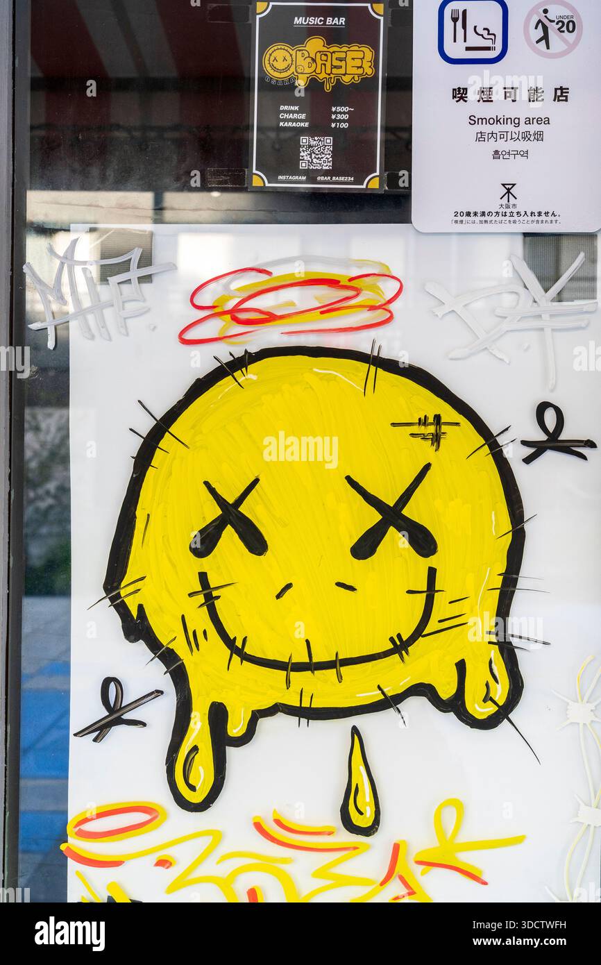 Betrunkene Kater gelbe Smiley-Face-Ikone an der Tür zu einer japanischen Musikbar im beliebten Shinsekai-Viertel von Osaka. Stockfoto