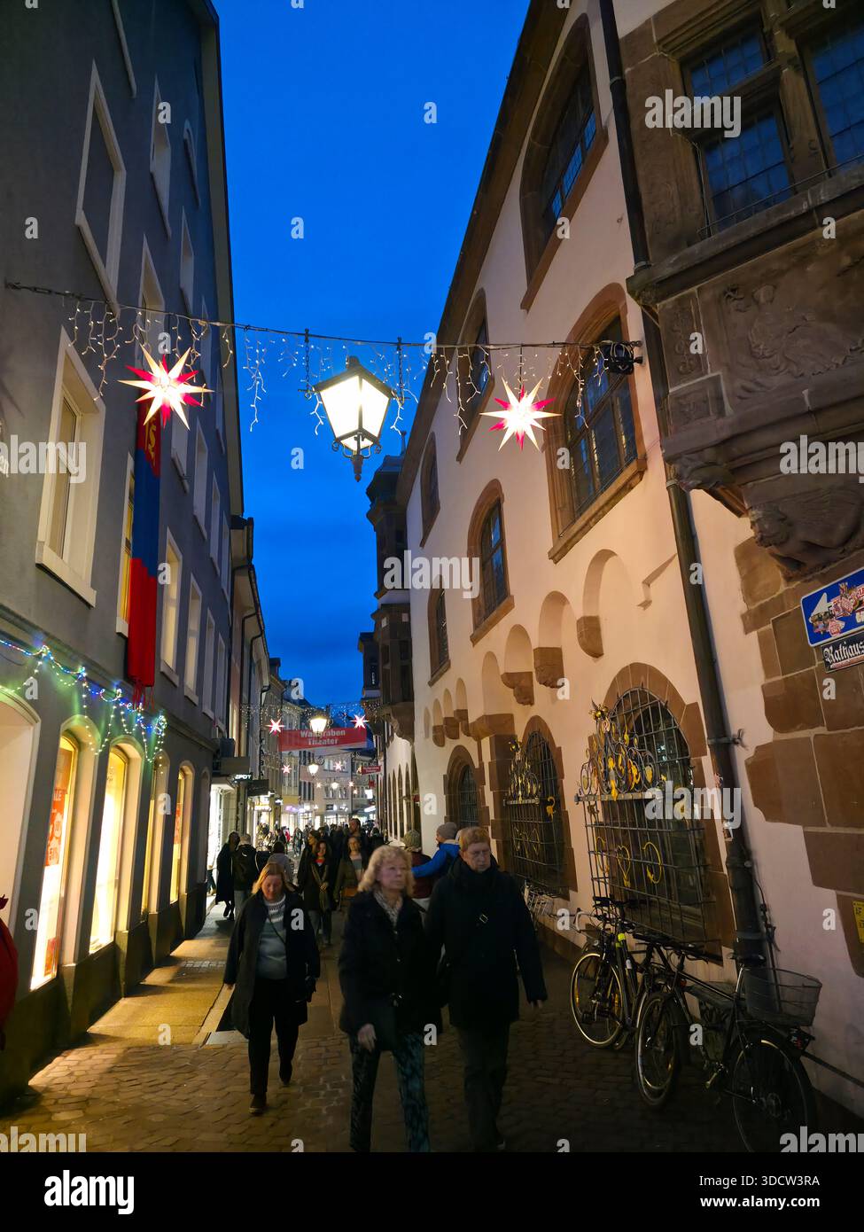 Freiburg im Breisgau, Deutschland, 19. Dezember 2025, berühmter Weihnachtsmarkt in der Altstadt voller Touristen zur blauen Stunde Stockfoto