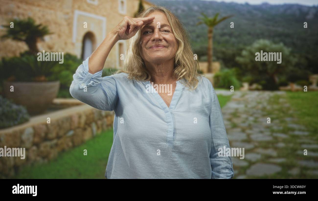Ältere Frau zeigt mit dem Finger auf den Tempel mit sichtbarer Hand vor einem Innenhof aus Stein; Vertrauen, Resilienz Weisheit. Stockfoto