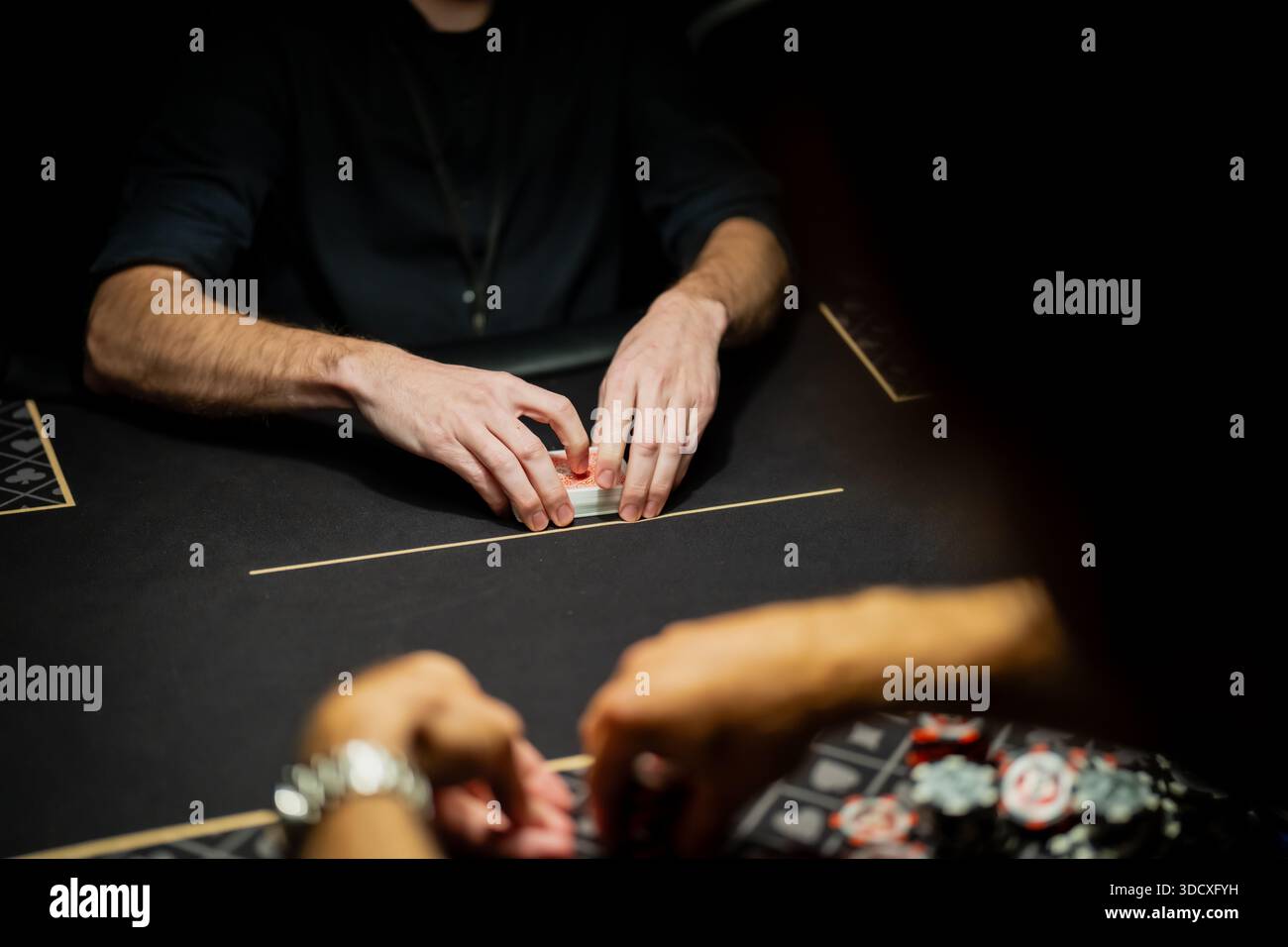 Live-Casino-Poker-Tischszene mit Händlern, die Kartendeck organisieren und Spieler warten auf Wetten, die kontrollierte Verfahren in der Gaming-Branche zeigen Stockfoto
