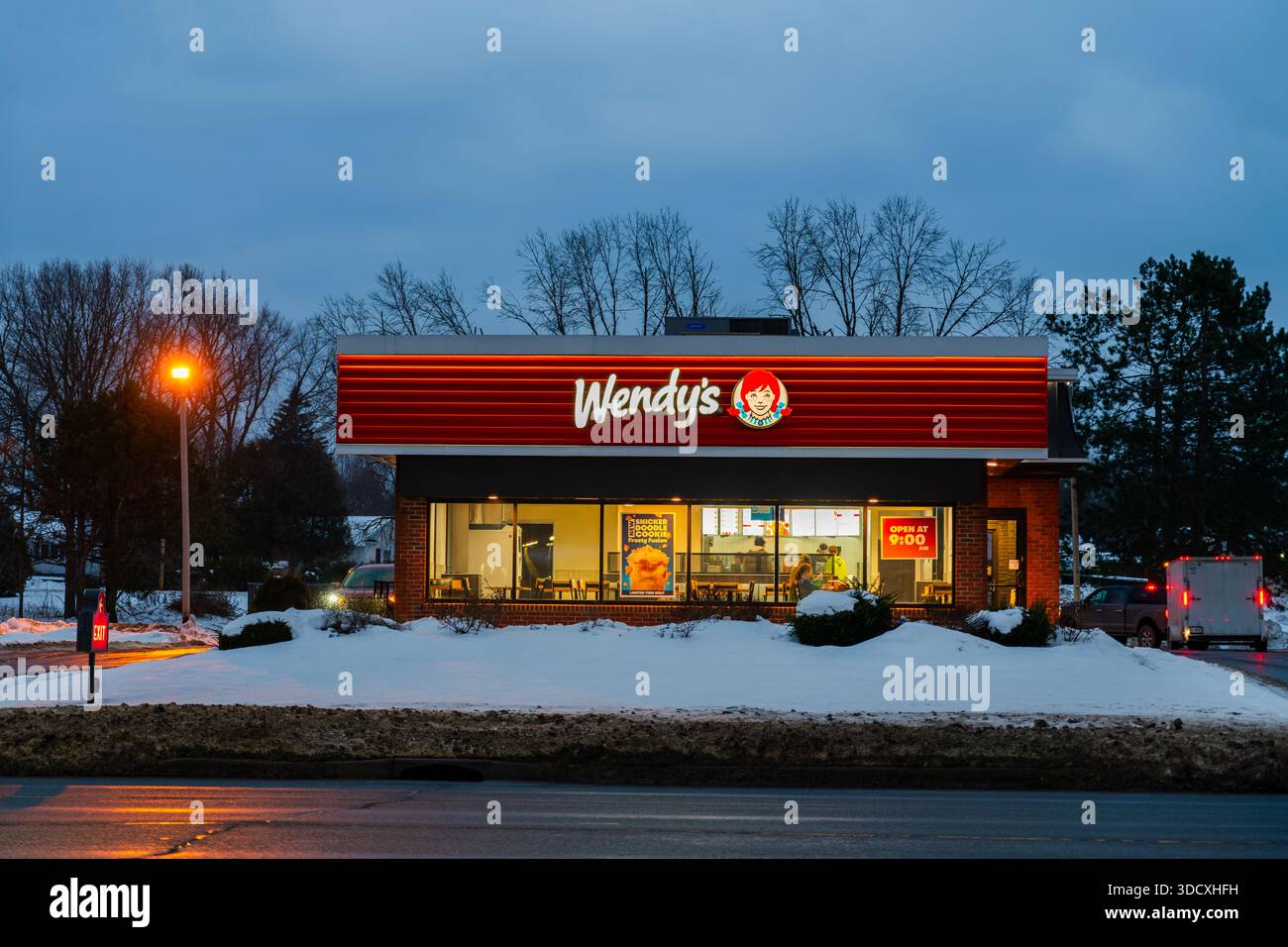 Yorkville, NY - 17. Dezember 2025: Nächtlicher Blick auf Wendys Einzelhandelsgeschäft in einem winterweißen Kleid. Wendy's ist eine internationale Fast-Food-Restaurantkette Stockfoto