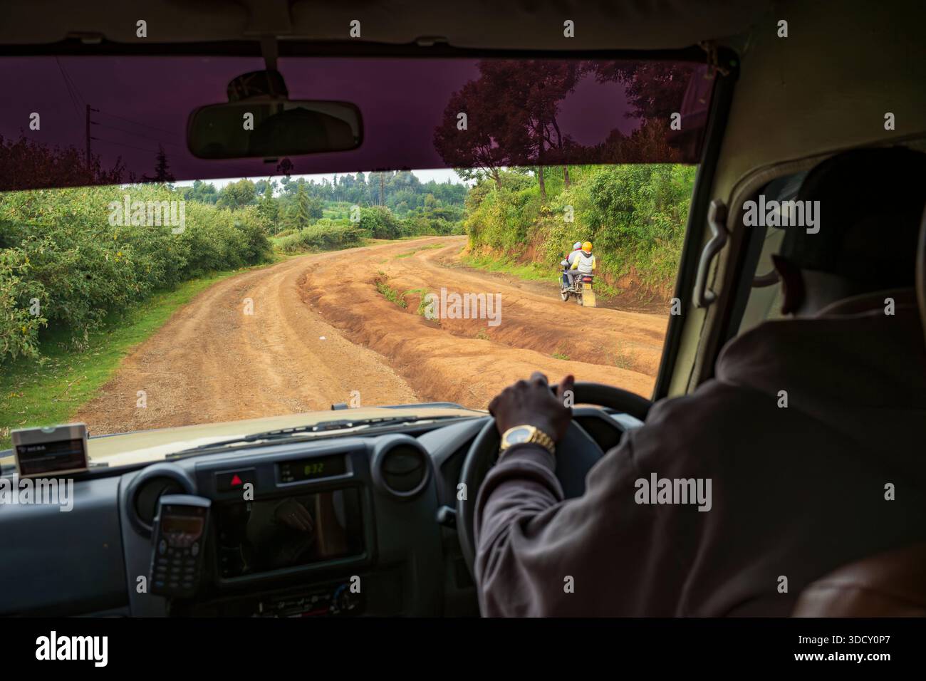 Migori, Kenia, - 21. Juni 2025: Ein Safari-Reiseleiter fährt ein Fahrzeug mit Allradantrieb auf einer unbefestigten kenianischen Straße, die erodiert ist. Das Straßennetz Afrikas Stockfoto