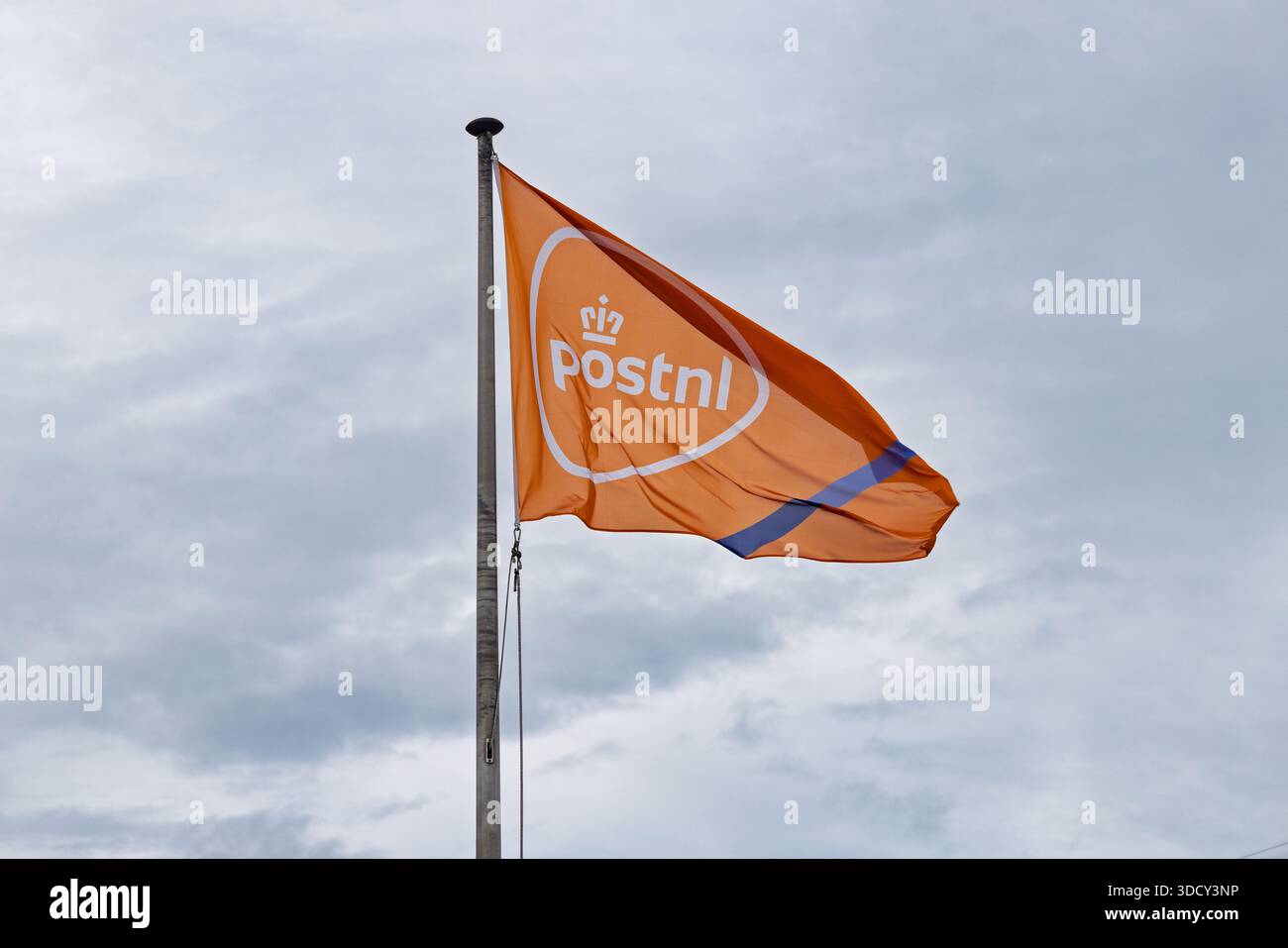 Eine orangefarbene Flagge mit dem weißen PostNL-Logo, das im Wind vor einem bewölkten Himmel winkt und den nationalen Postdienst repräsentiert. Utrecht Niederlande, 3 Stockfoto