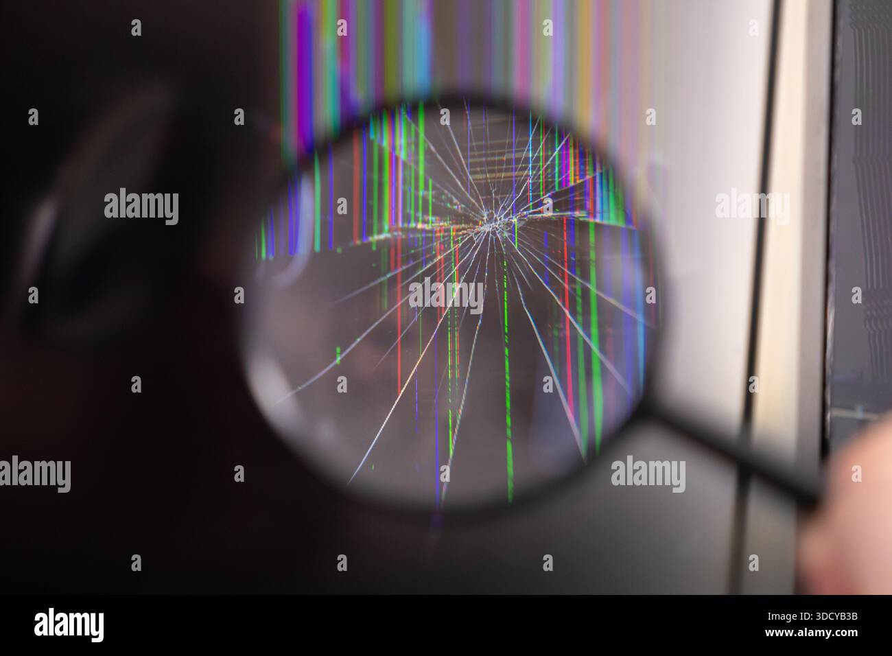 Nahaufnahme einer Lupe über einem kaputten LCD- oder LED-Display mit Starburst-Rissen und mehrfarbigen vertikalen Pixeln, Hervorhebungsvorrichtung Stockfoto
