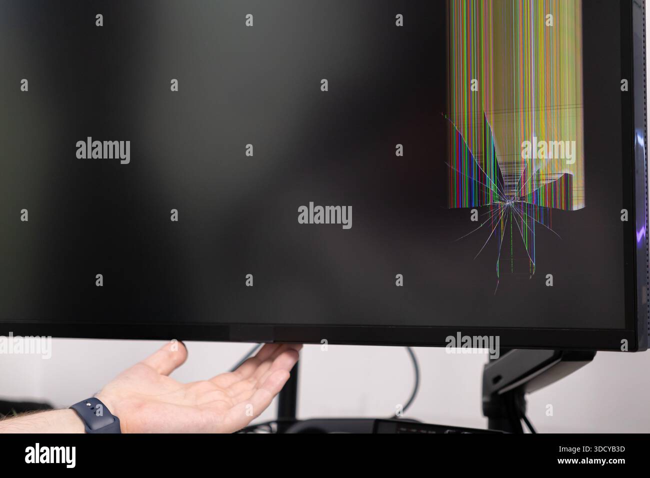 Detaillierte Ansicht einer menschlichen Hand mit einem stark gebrochenen Bildschirm, mit Starburst-Glasrissen und lebhaften, bunten vertikalen Linien von imp Stockfoto