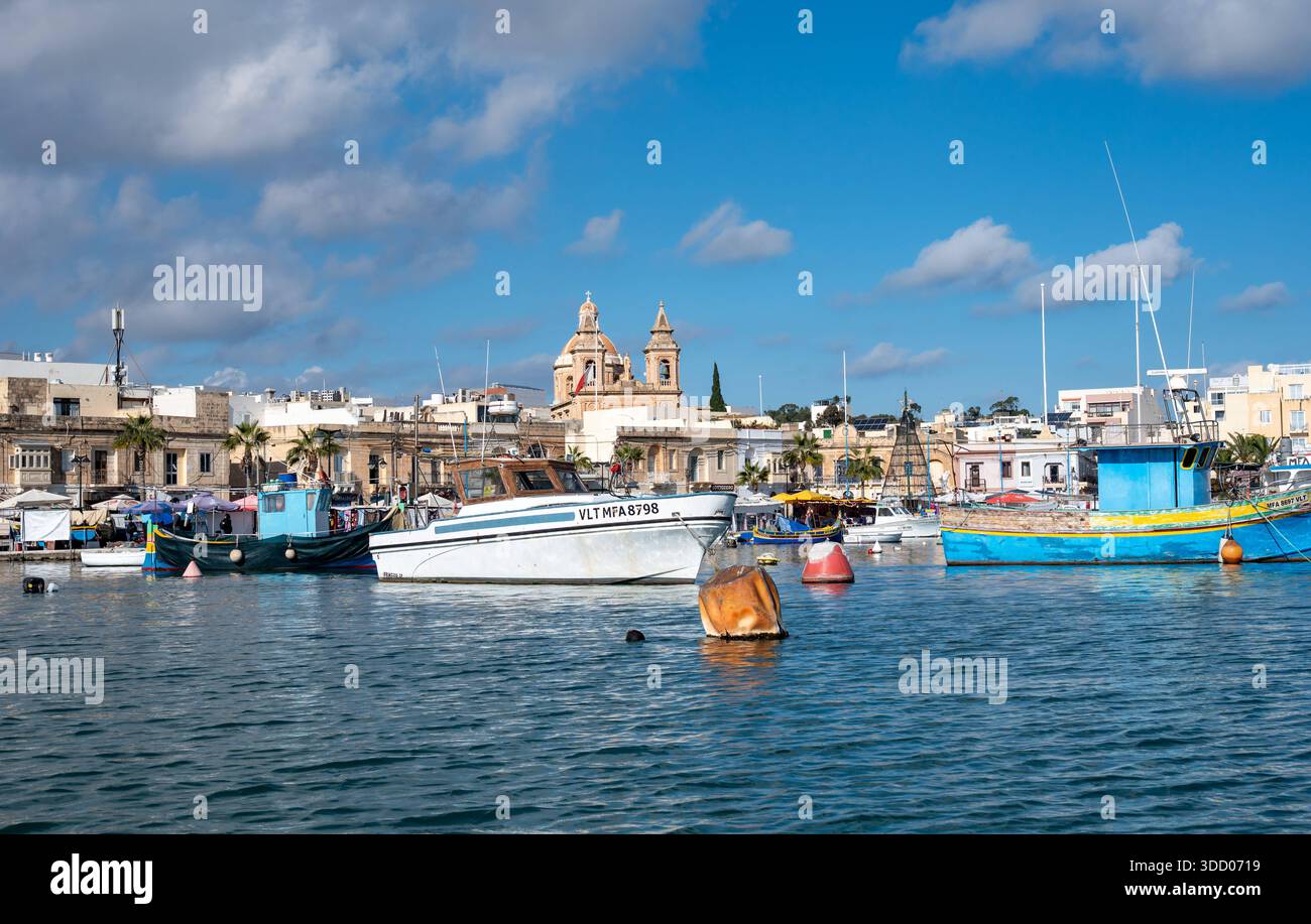 Sommeratmosphäre im Küstendorf Marsaxlokk mit farbenfrohen traditionellen Fischerbooten im alten Hafen Marsaxlokk, Malta, 11. Dezember 2025 Stockfoto