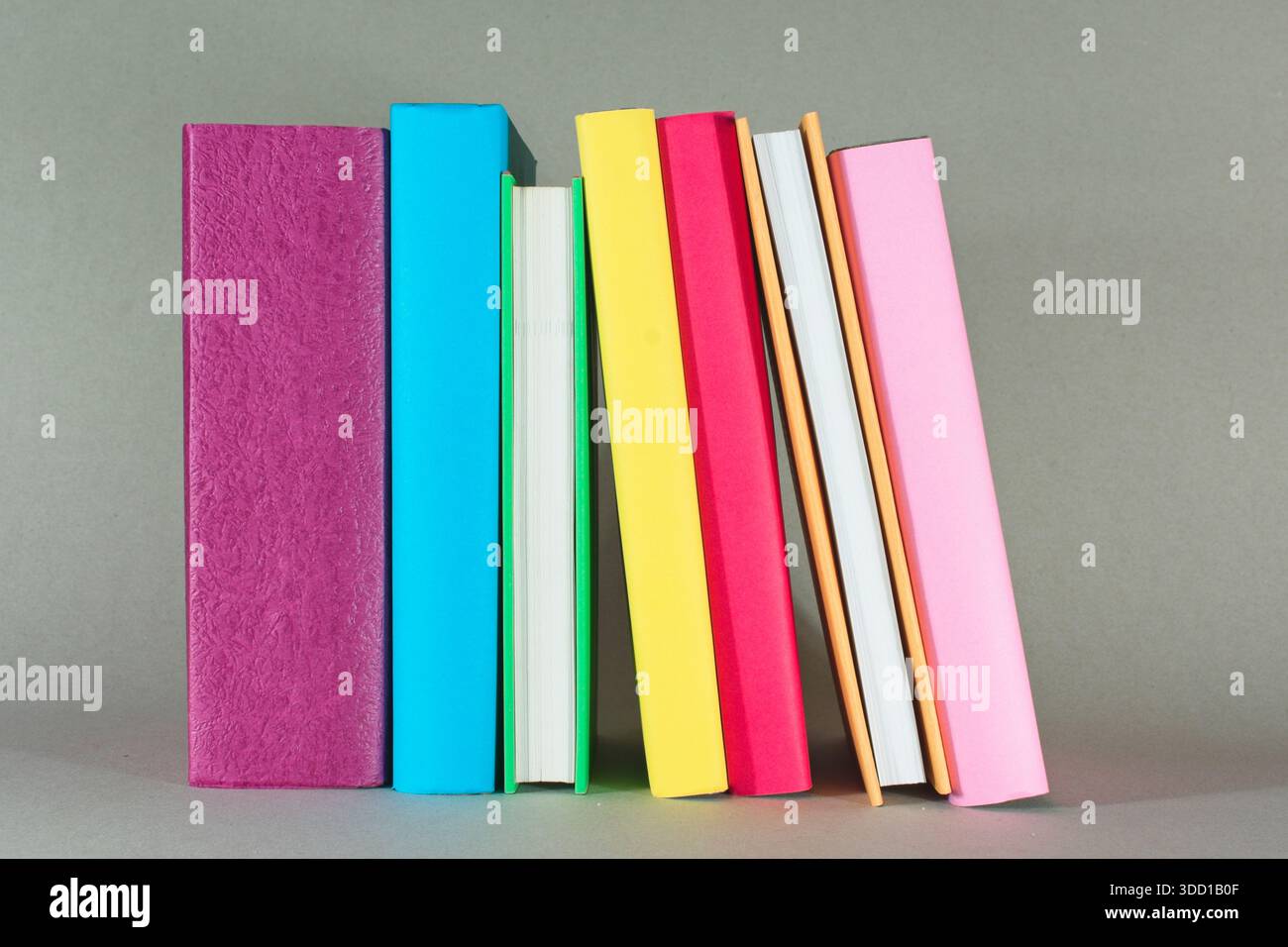 Ein Stapel farbenfroher Bücher auf einem Tisch veranschaulicht Lesen, Literatur, Lernen, Bildung und Wissen. Stockfoto