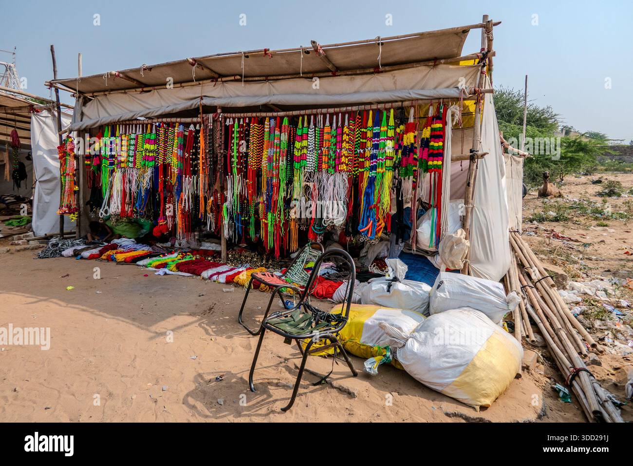 Pushkar, Indien, 26. Oktober 2025. Schauplatz des täglichen Lebens während der jährlichen Messe. Verkauf von farbenfrohen Kamelhalsen, Leinen und anderem Zubehör. Stockfoto