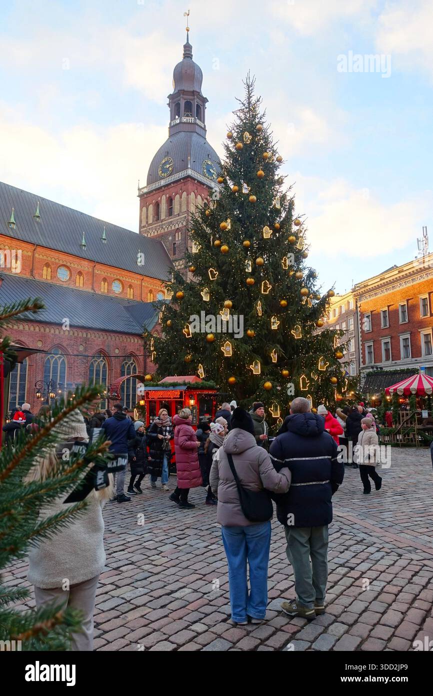Unerkannte Touristen auf dem Weihnachtsmarkt in der Nähe des Rigaer Doms am Abend in Riga, Lettland Stockfoto