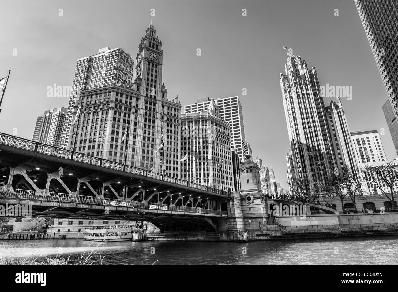 Monochromer Blick vom Flussniveau der DuSable Bridge, der das historische Wrigley Building und den Tribune Tower in Chicago einrahmt. Stockfoto