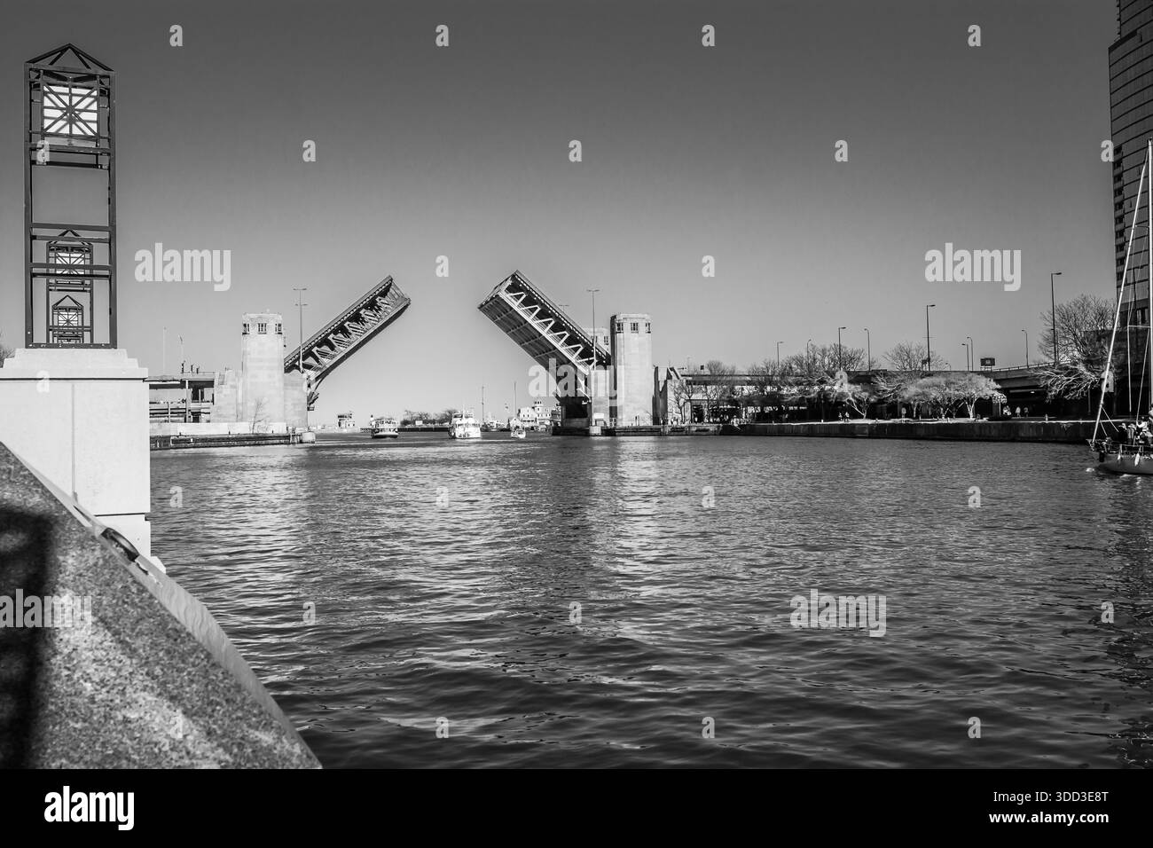 Monochromer Blick auf die geöffnete Klappbrücke am Lake Shore Drive, die für die Schifffahrt an der Mündung des Chicago River angehoben ist. Stockfoto
