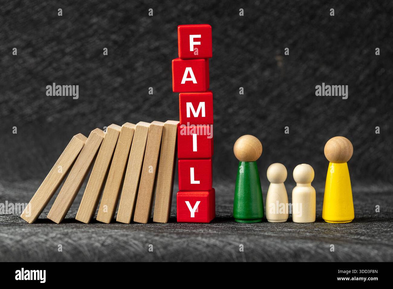 Bedrohung der Familie. Domino-Effekt, das Familienwort und hölzerne Miniaturen von Eltern mit Kindern unter dem Druck von Problemen und Herausforderungen. Eg Stockfoto