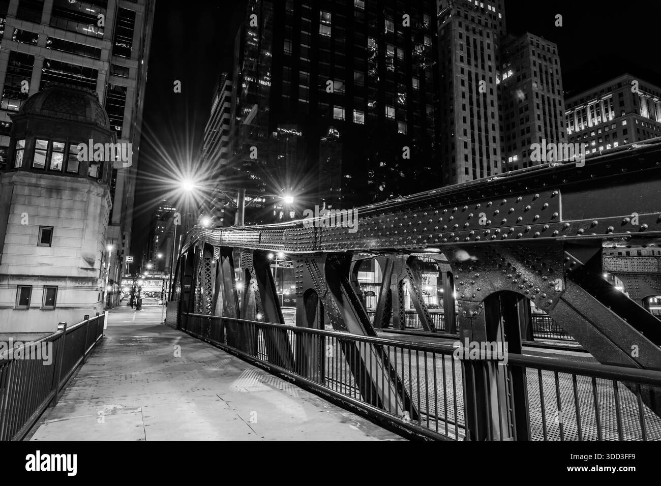 Monochromatische Nachtperspektive der genieteten Stahlträger, des Brückenwärterhauses und des Stegs der La Salle Street Bridge in Chicago. Stockfoto